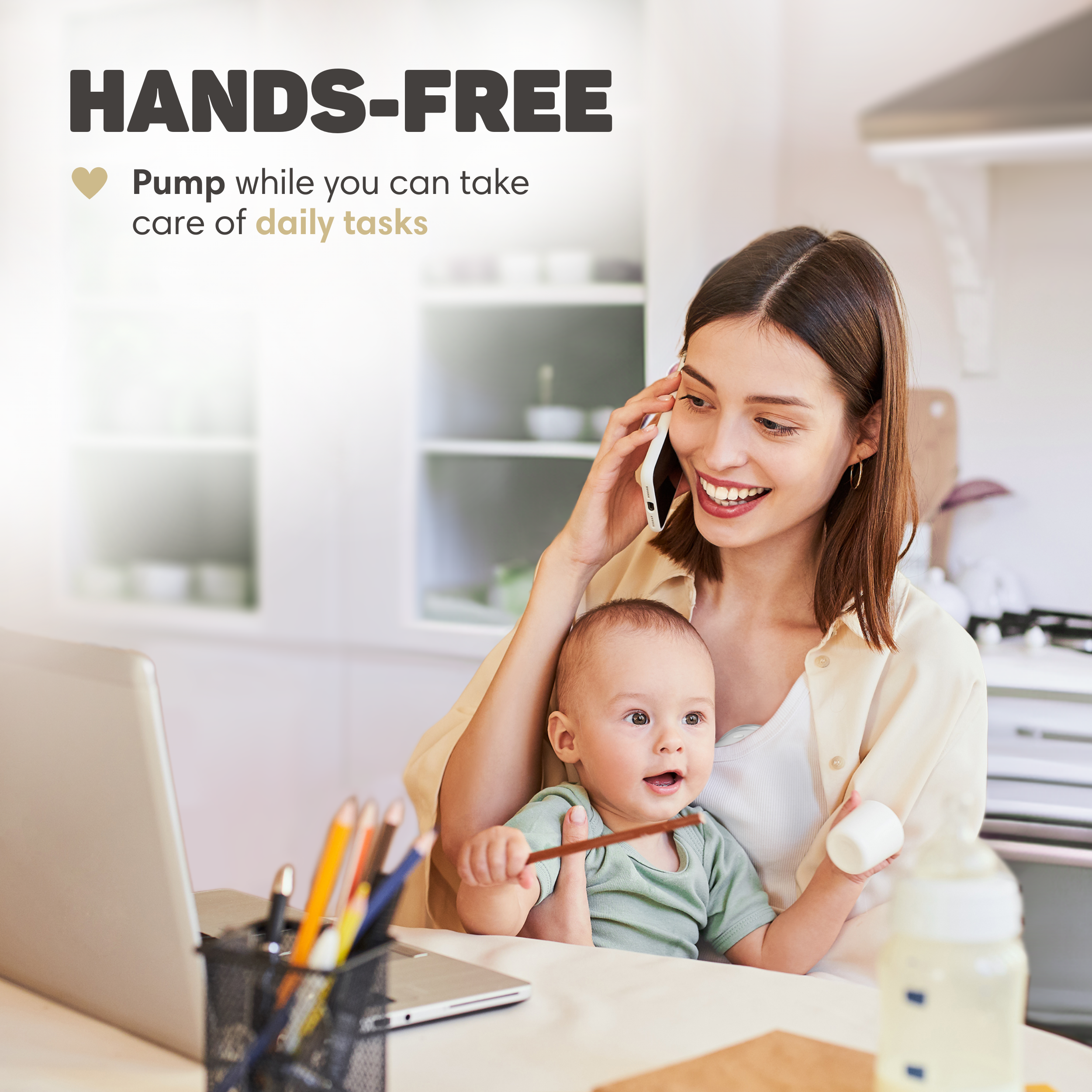 Eine Frau telefoniert und hält ein Baby, während sie auf einen Laptop starrt.