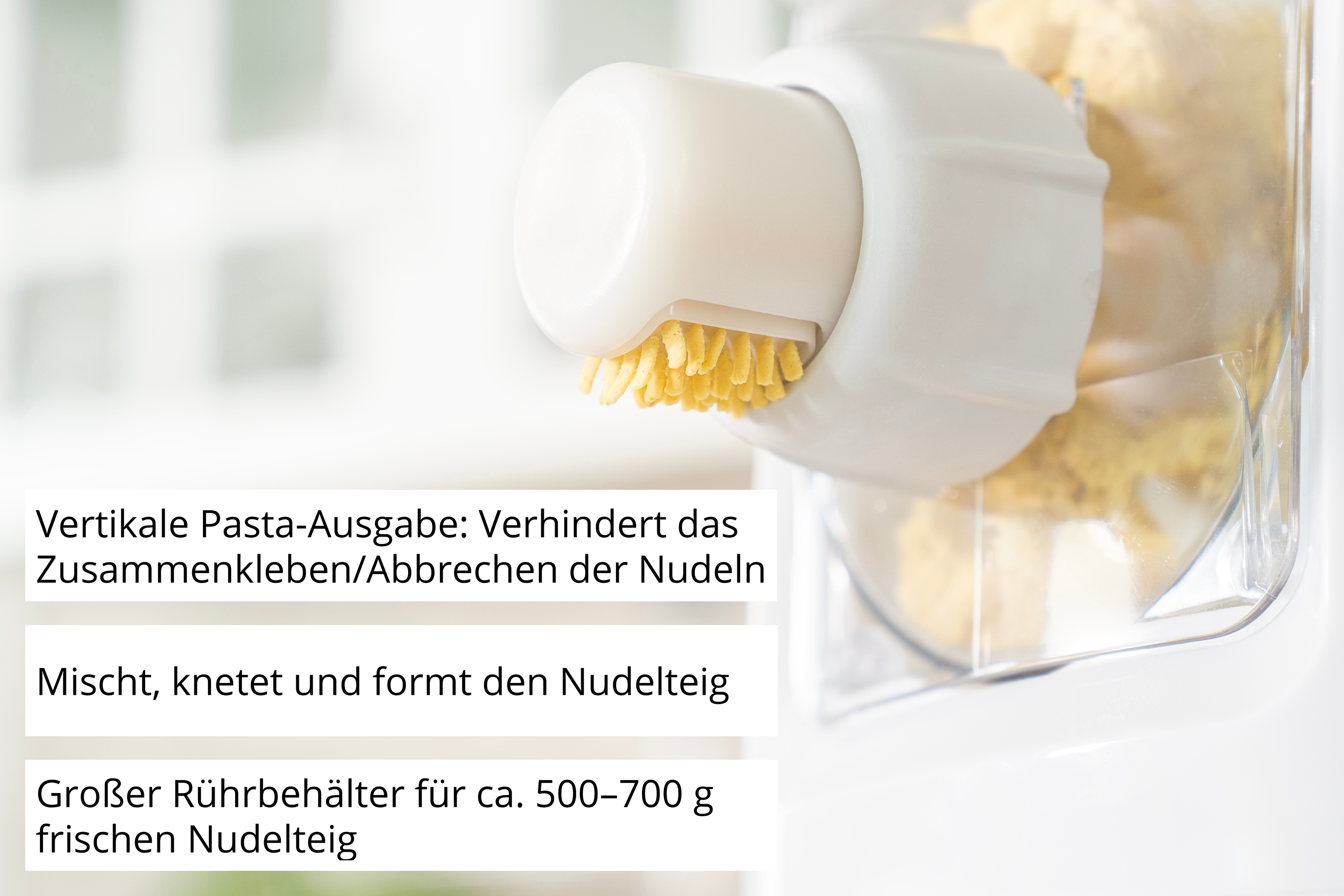 Eine weiße Nudelmaschine mit gelbem Teig. Nahaufnahme des Ausgabemechanismus.