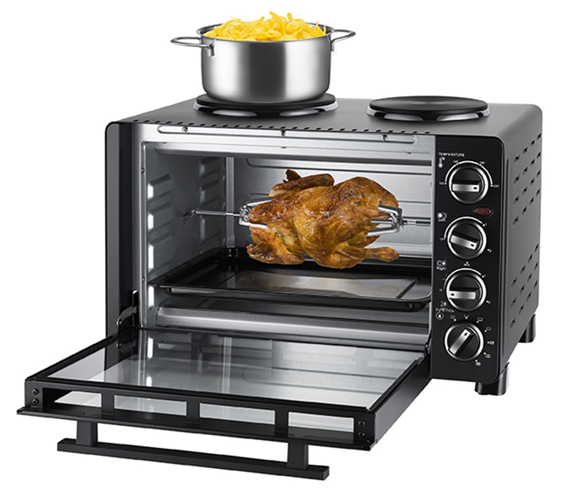 Un pollo allo spiedo cuoce in un forno. Sopra c'è una pentola di pasta.