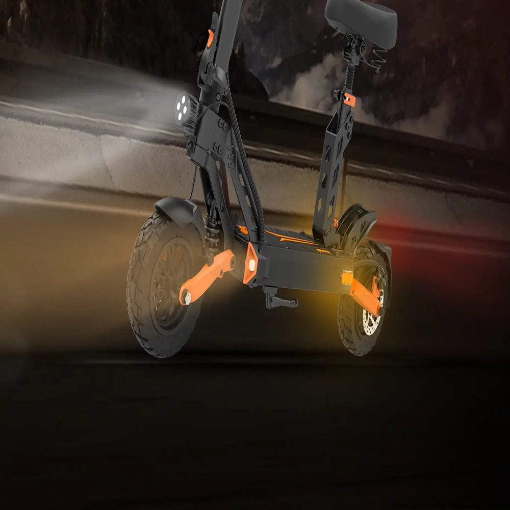 Un patinete eléctrico negro con detalles naranjas circula por una carretera oscura.