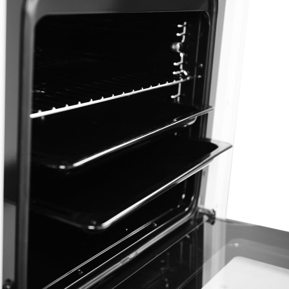 Gros plan de l'intérieur d'un four ouvert avec grilles et plaques de cuisson.