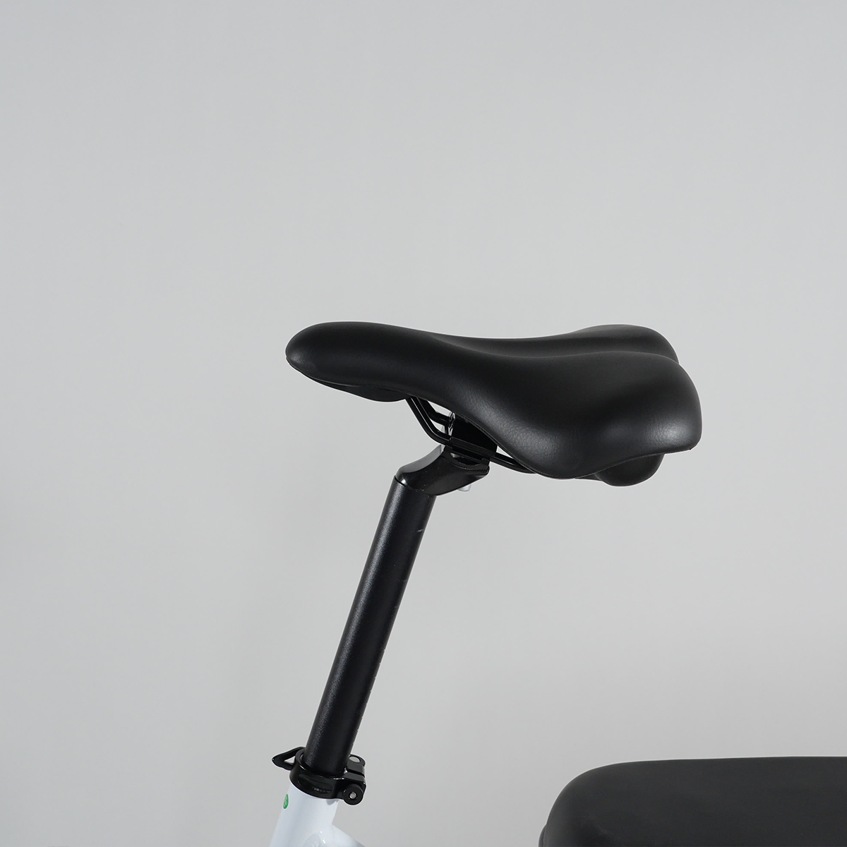 Czarno-białe siodełko rowerowe na szarym tle.