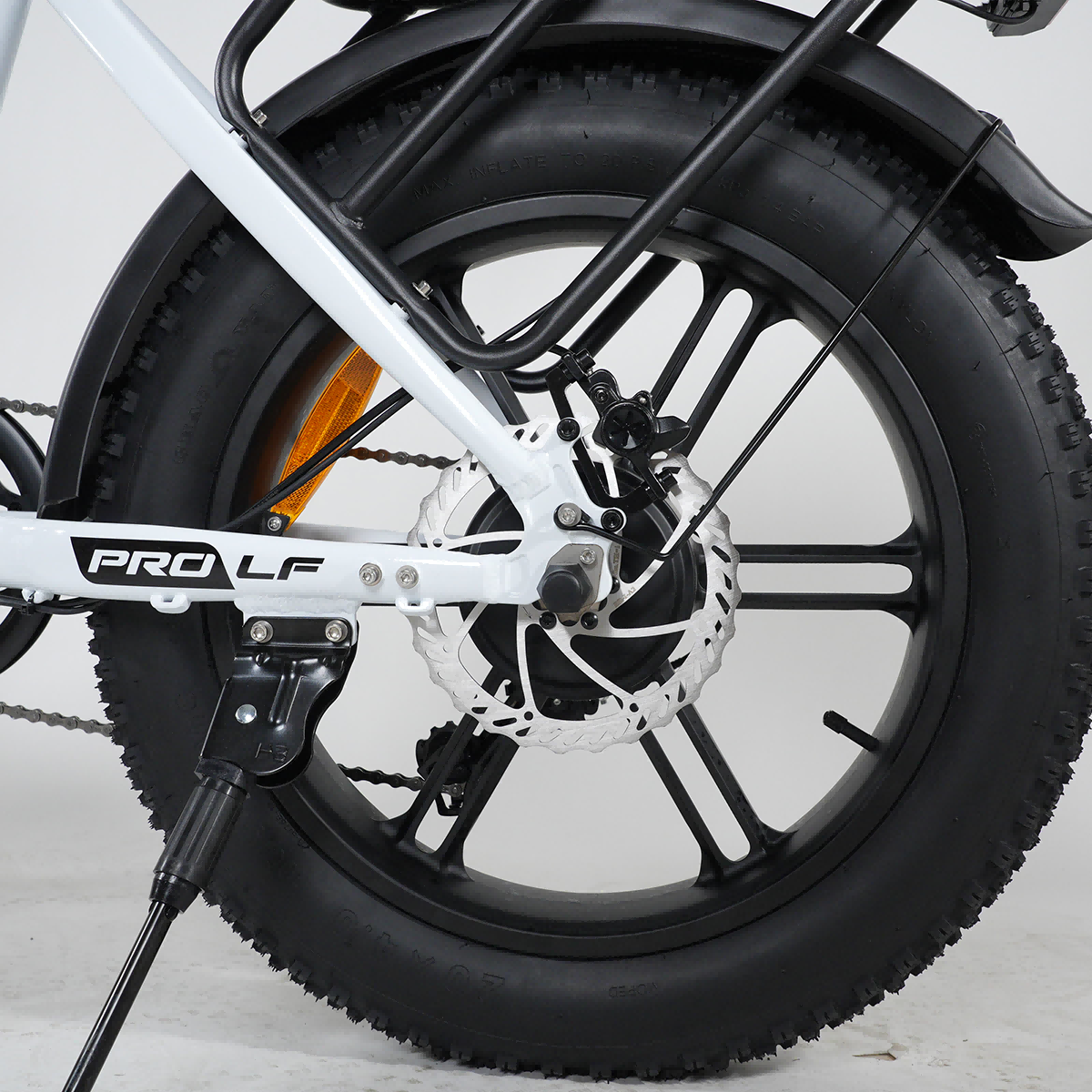 Zbliżenie tylnego koła białego roweru z czarnymi oponami i felgami.