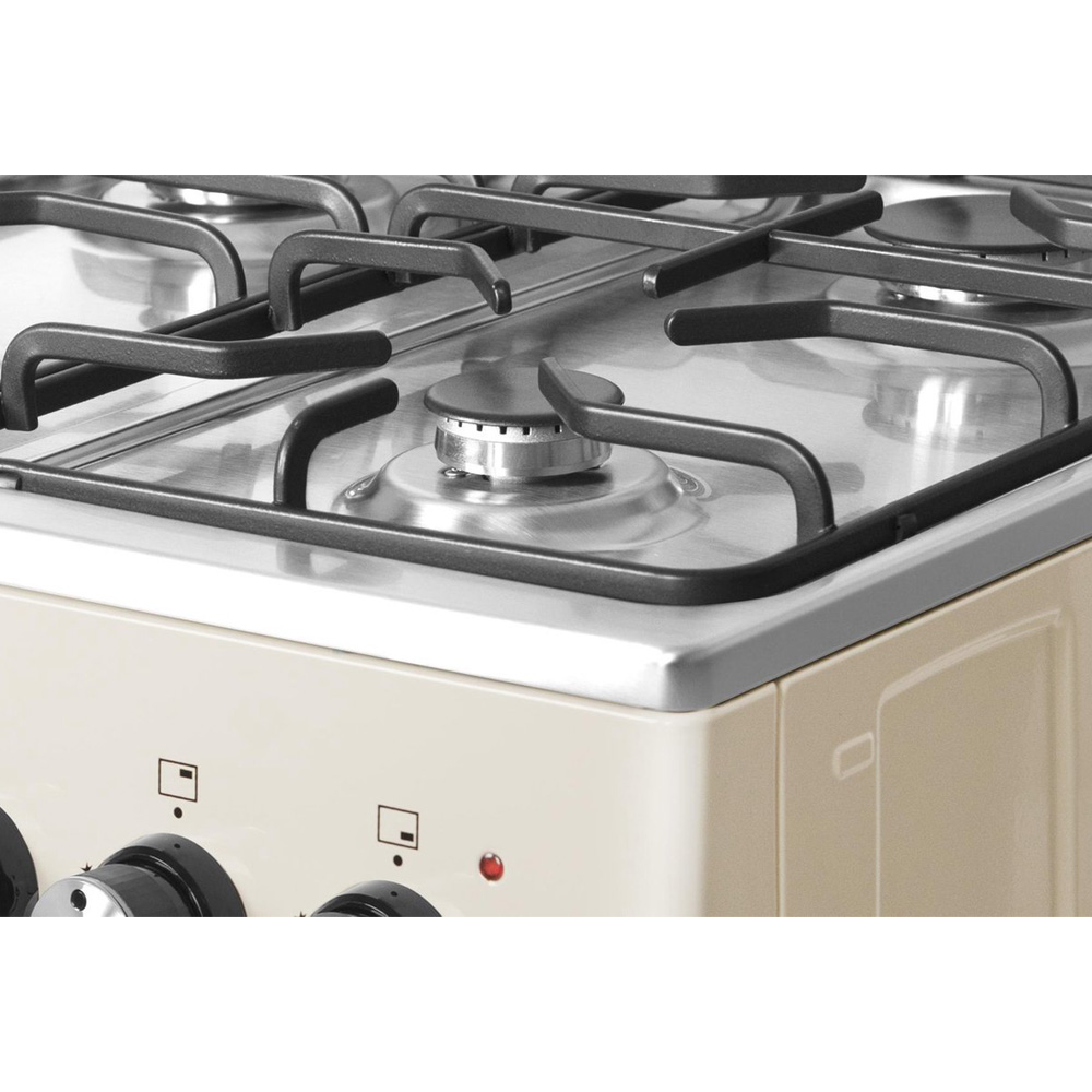 Close-up of a cream-colored gas stove with a stainless steel top and black grates.