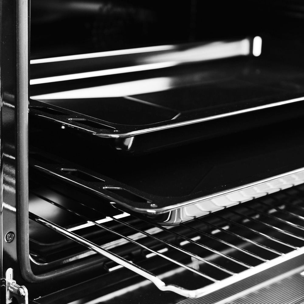 Interior view of an oven with two baking sheets on racks.