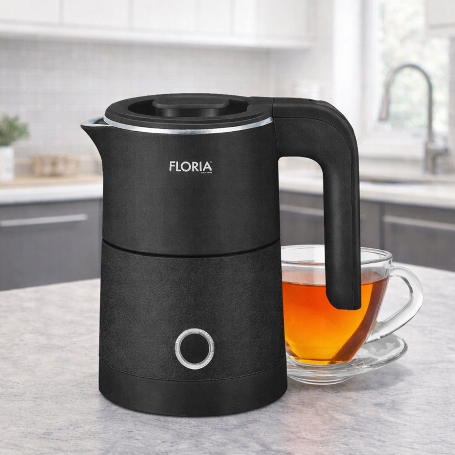 Czajnik elektryczny z uchwytem obok filiżanki herbaty, kuchnia.