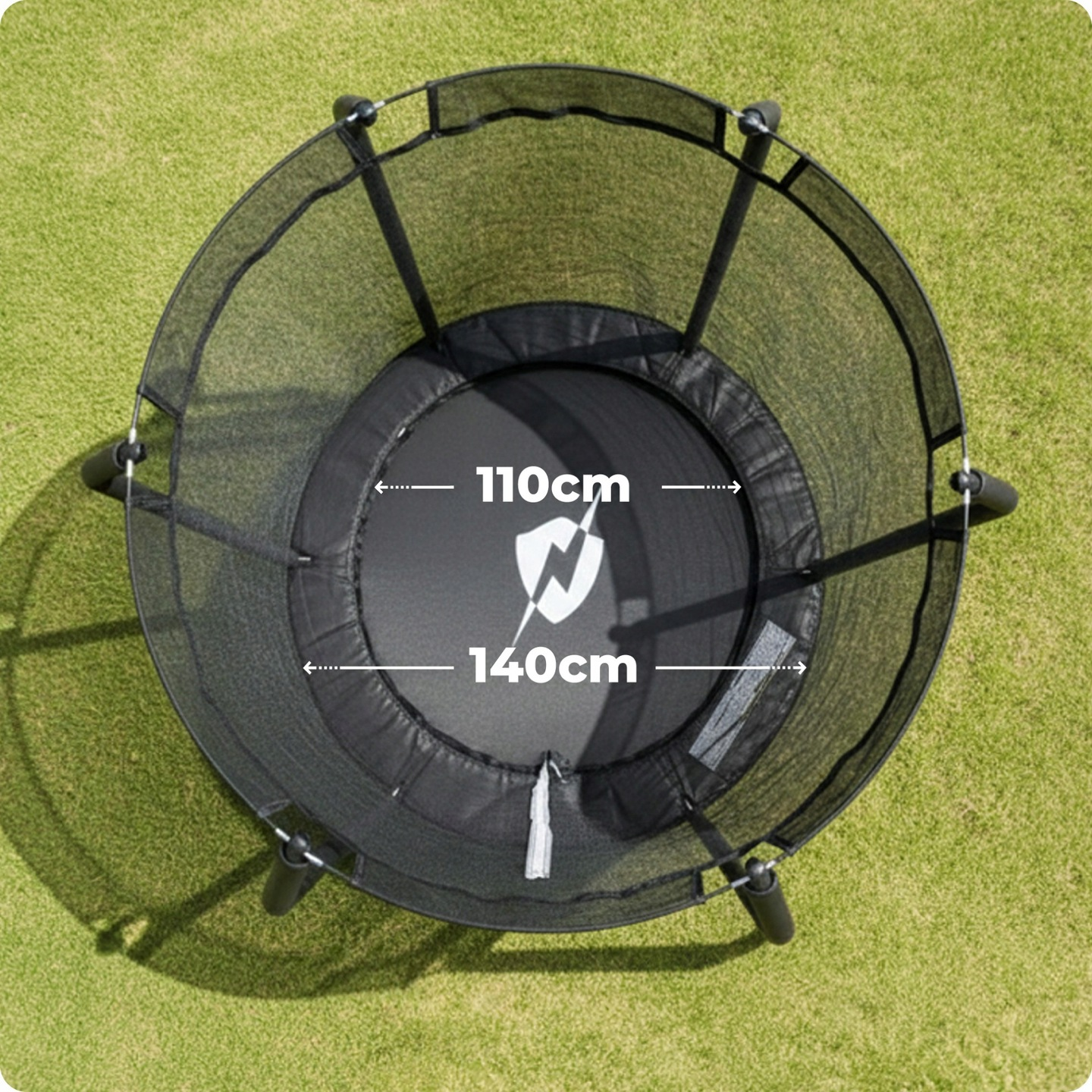 Czarna trampolina z siatką zabezpieczającą na zielonej trawie.