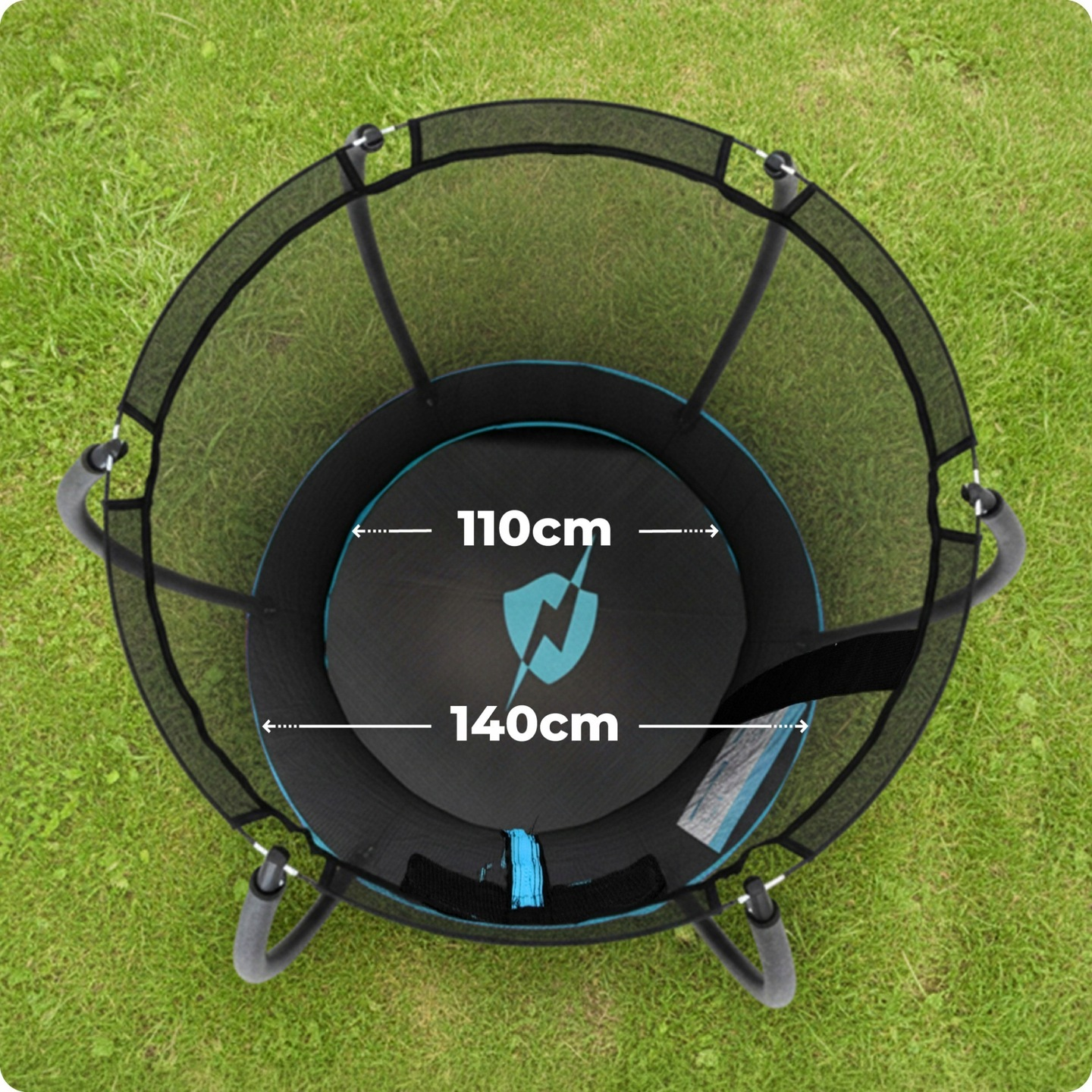 Okrągły trampolin z siatką ochronną, stojący na zielonej trawie.