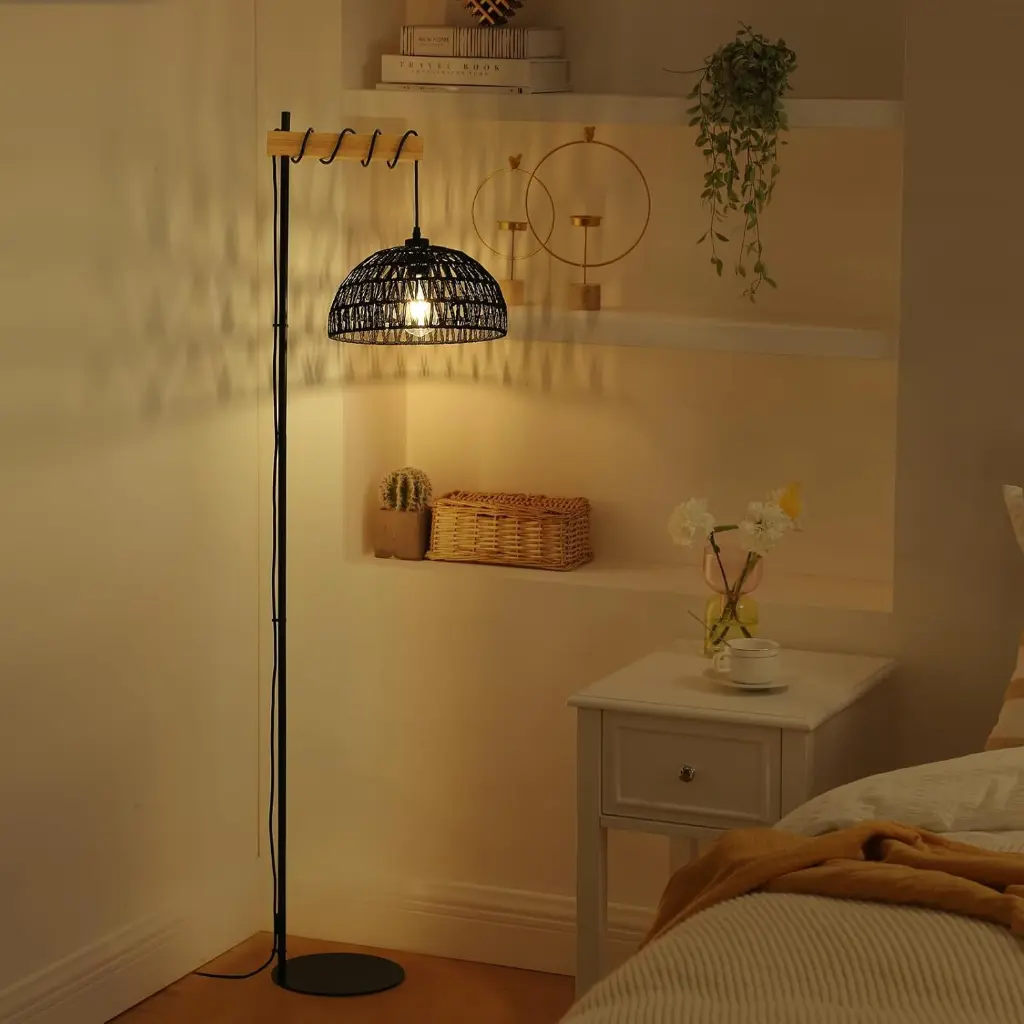 Una lámpara de pie de ratán negra con detalles de madera ilumina un dormitorio.