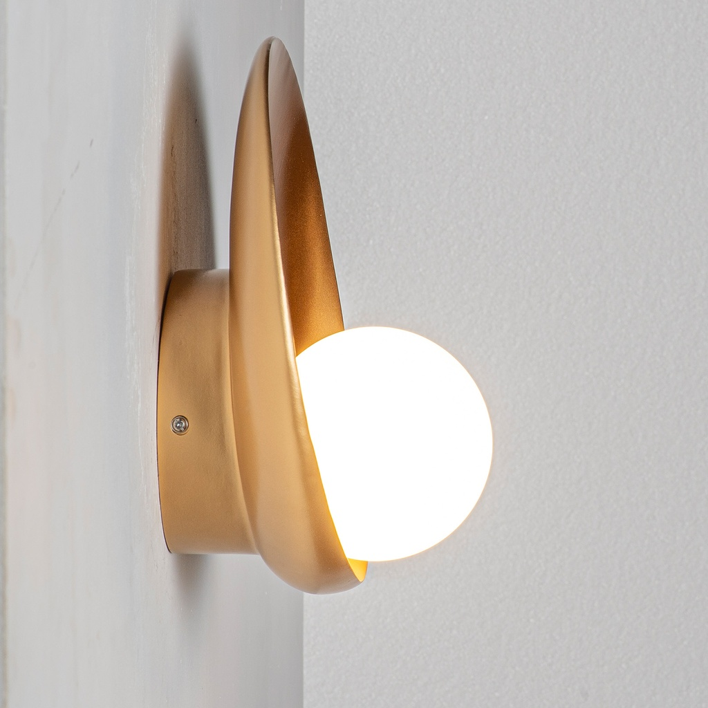 Una lámpara de pared dorada con una bombilla blanca esférica.