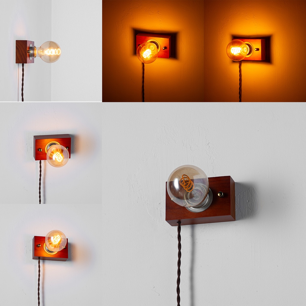 Lámpara de pared de madera con bombilla y cable negro sobre pared blanca.