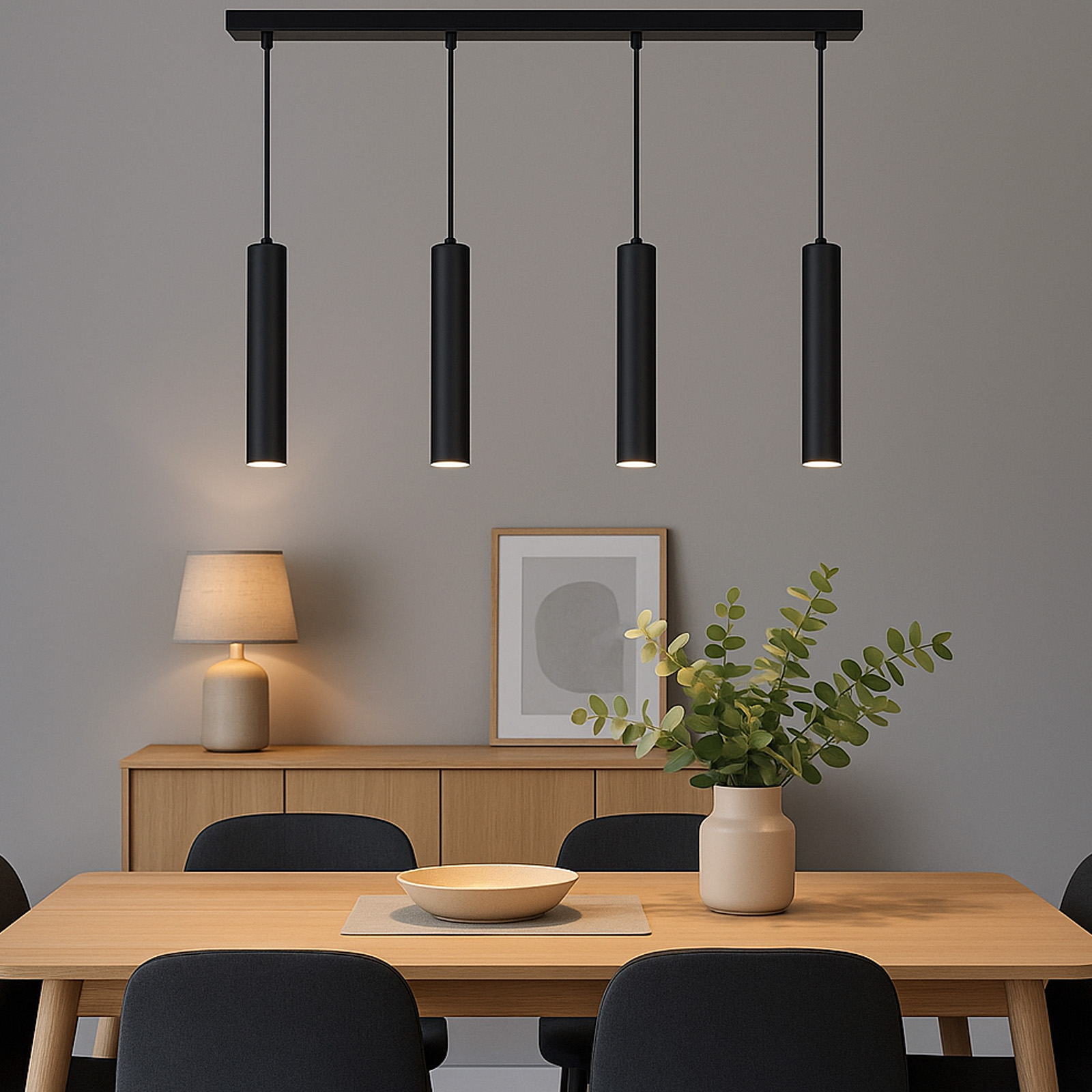 Cuatro lámparas colgantes cilíndricas negras cuelgan sobre una mesa de comedor de madera.
