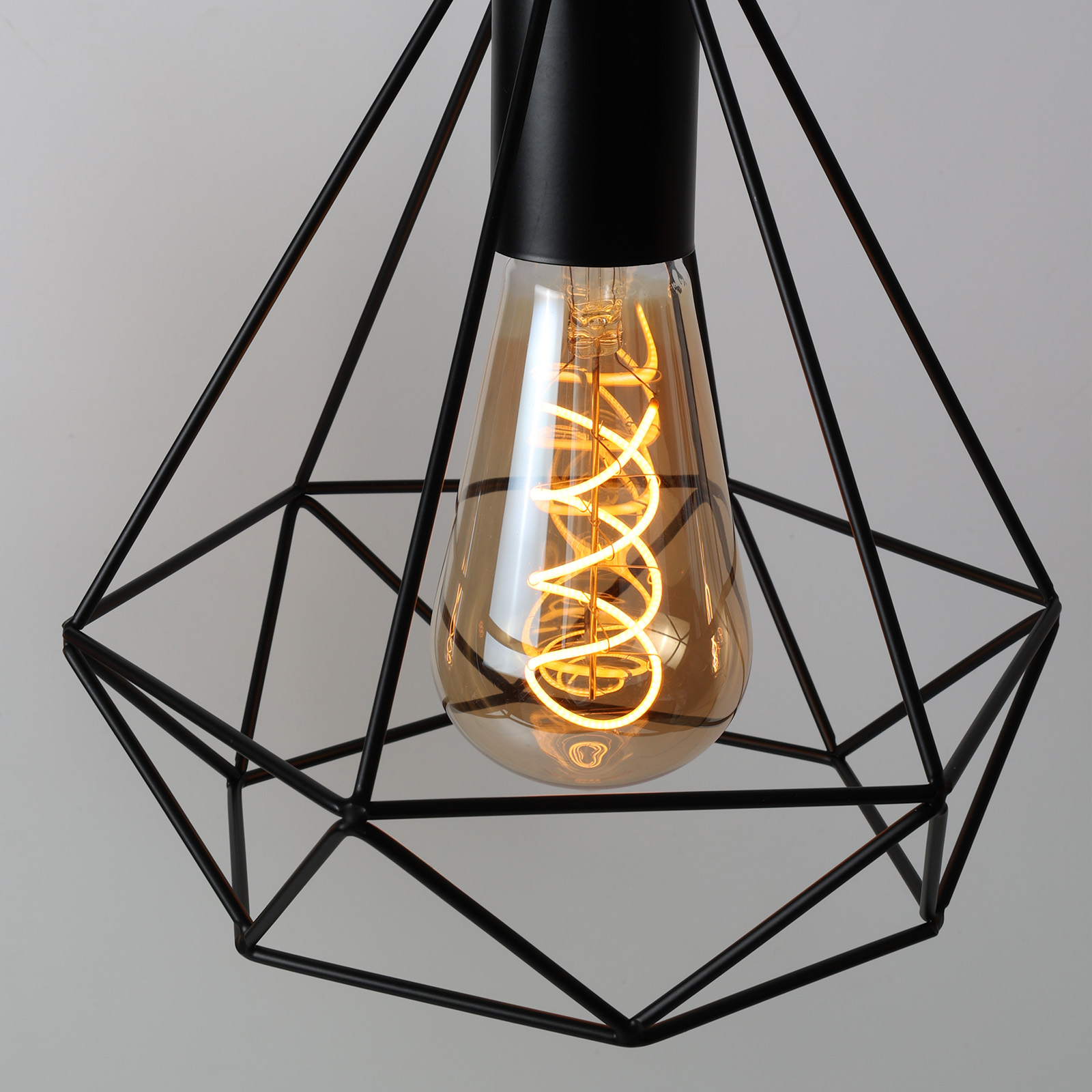 Un candelabro moderno con una jaula de alambre negra y una bombilla Edison.