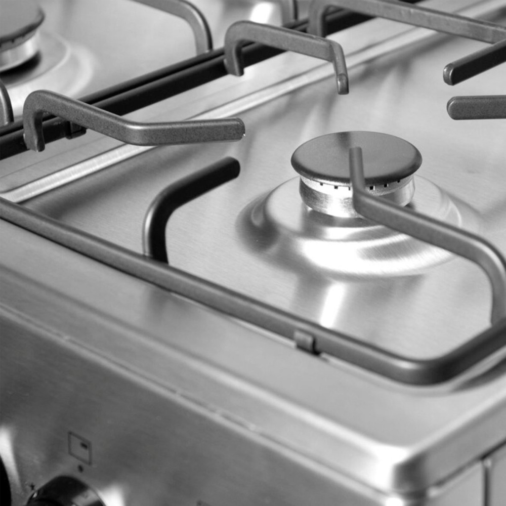 Close-up van een roestvrijstalen gasfornuis met branders en roosters.