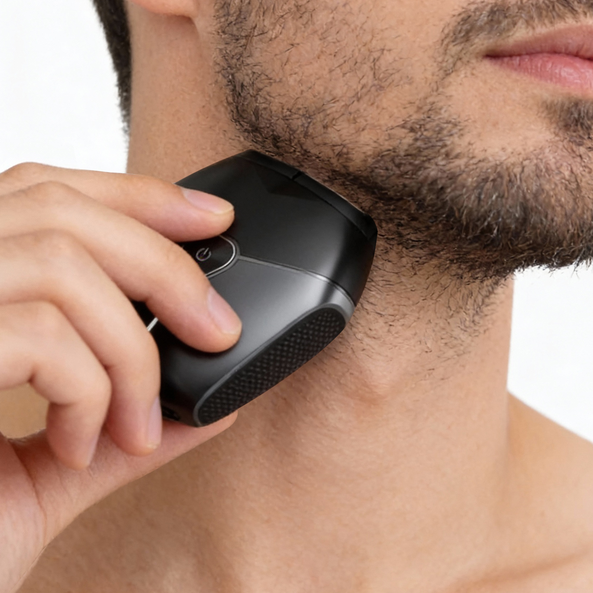 Hombre se afeita la barbilla y el cuello con una afeitadora eléctrica negra.