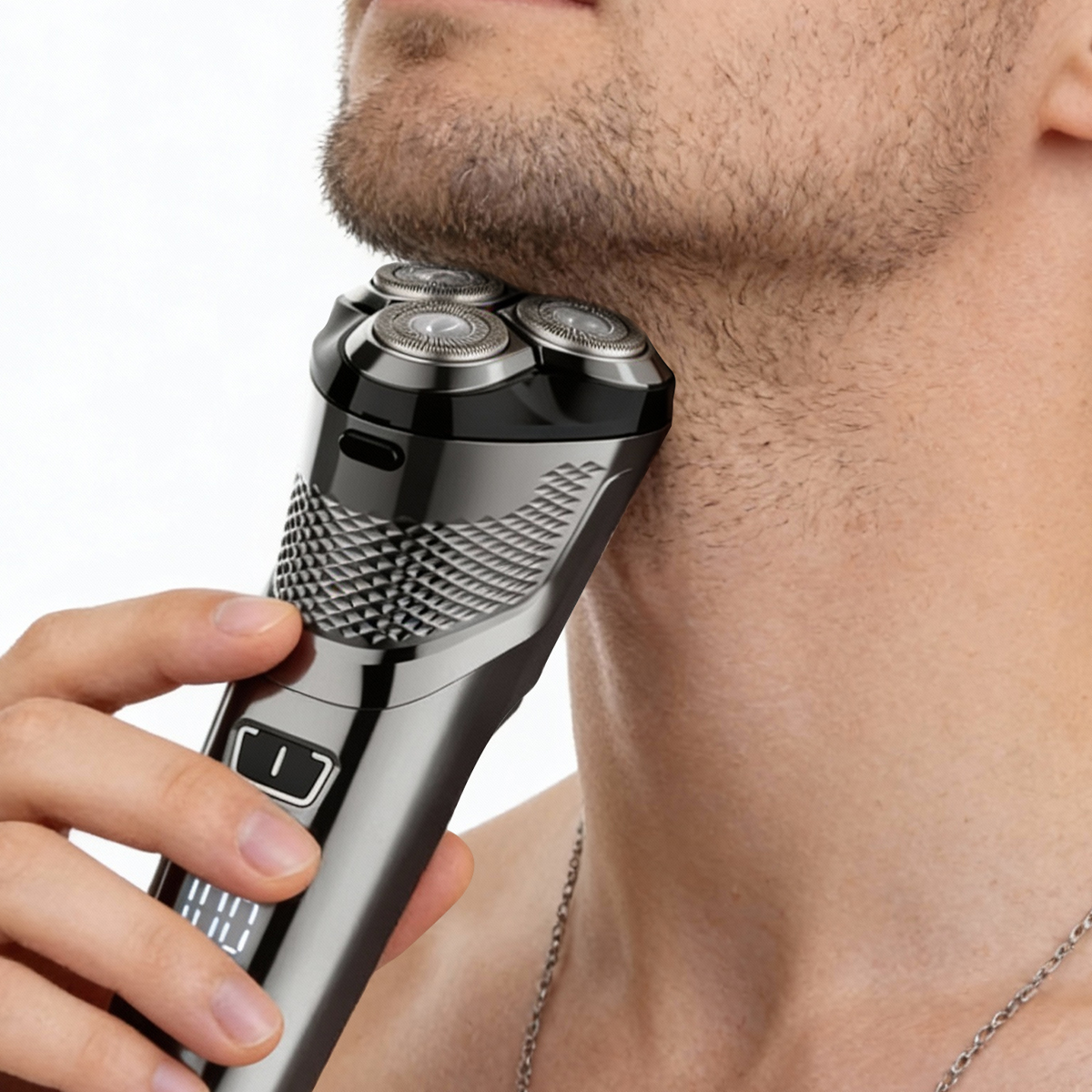 Hombre afeitándose la barba con una afeitadora eléctrica.
