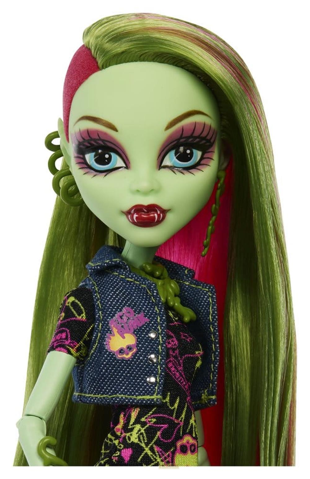 Eine grüne Puppe mit langen Haaren, blauem Lidschatten und einem Jeans-Oberteil.