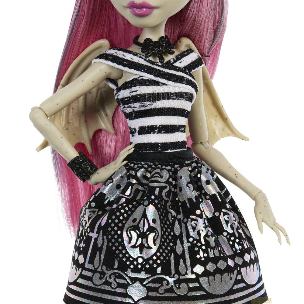 Eine Puppe mit langen rosa Haaren trägt ein schwarz-weiß gestreiftes Oberteil und einen Rock.