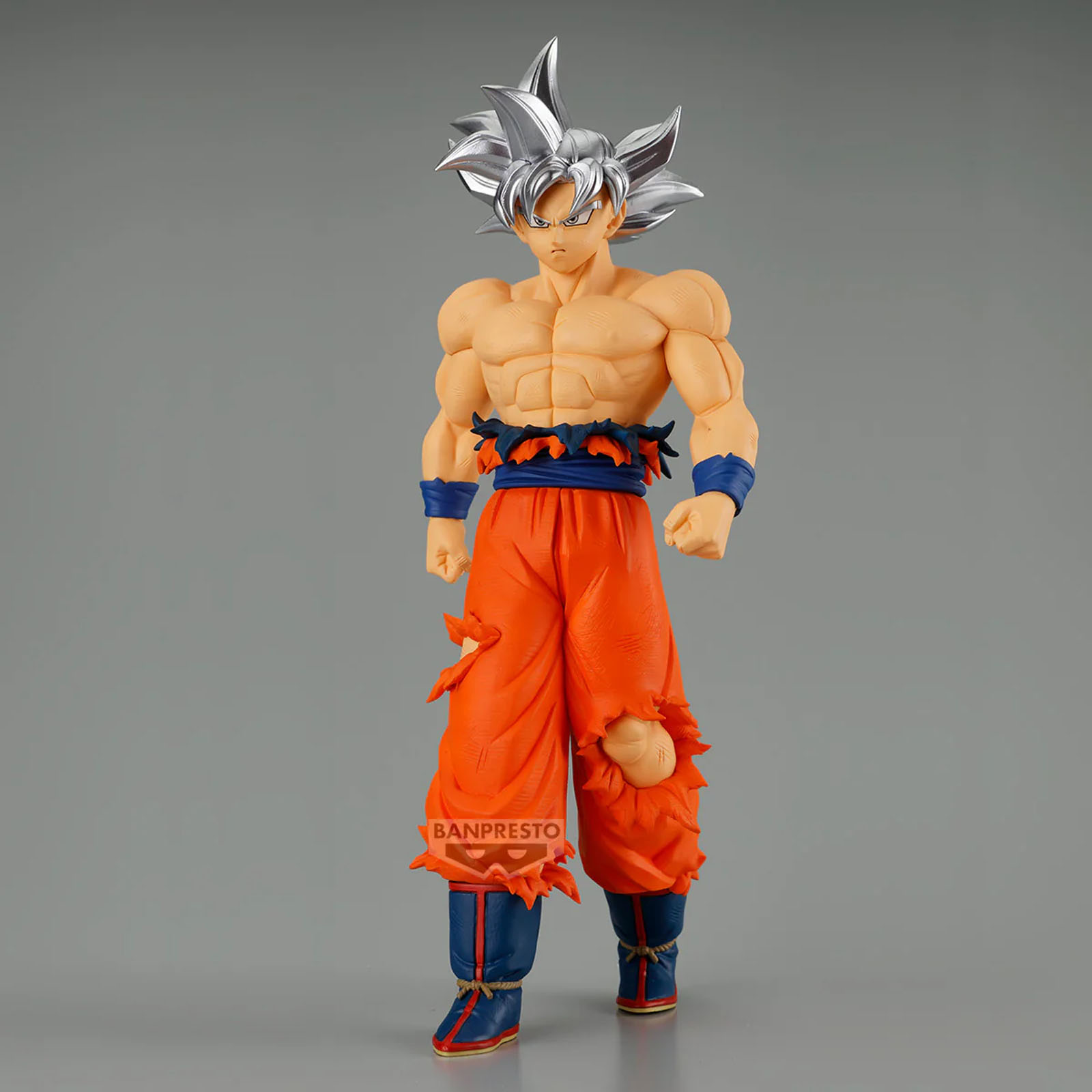 Eine Actionfigur von Goku mit silbernem Haar und zerrissener oranger Kleidung.