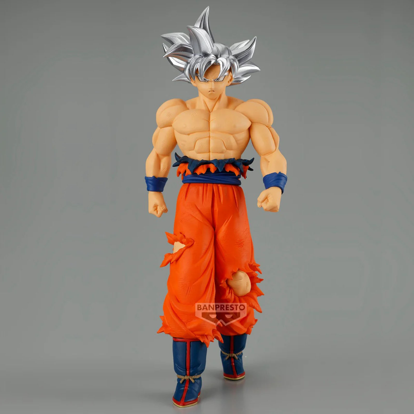 Eine Figur von Goku in Ultra Instinct Form mit weißen Haaren und orangefarbener Kleidung.