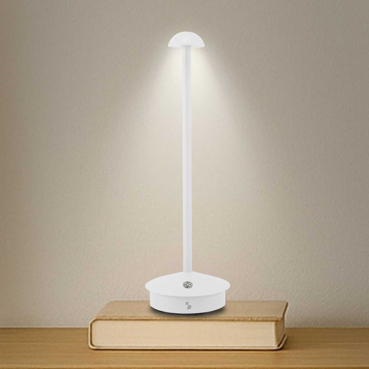 Una lampada da scrivania LED bianca con collo flessibile è su un libro.