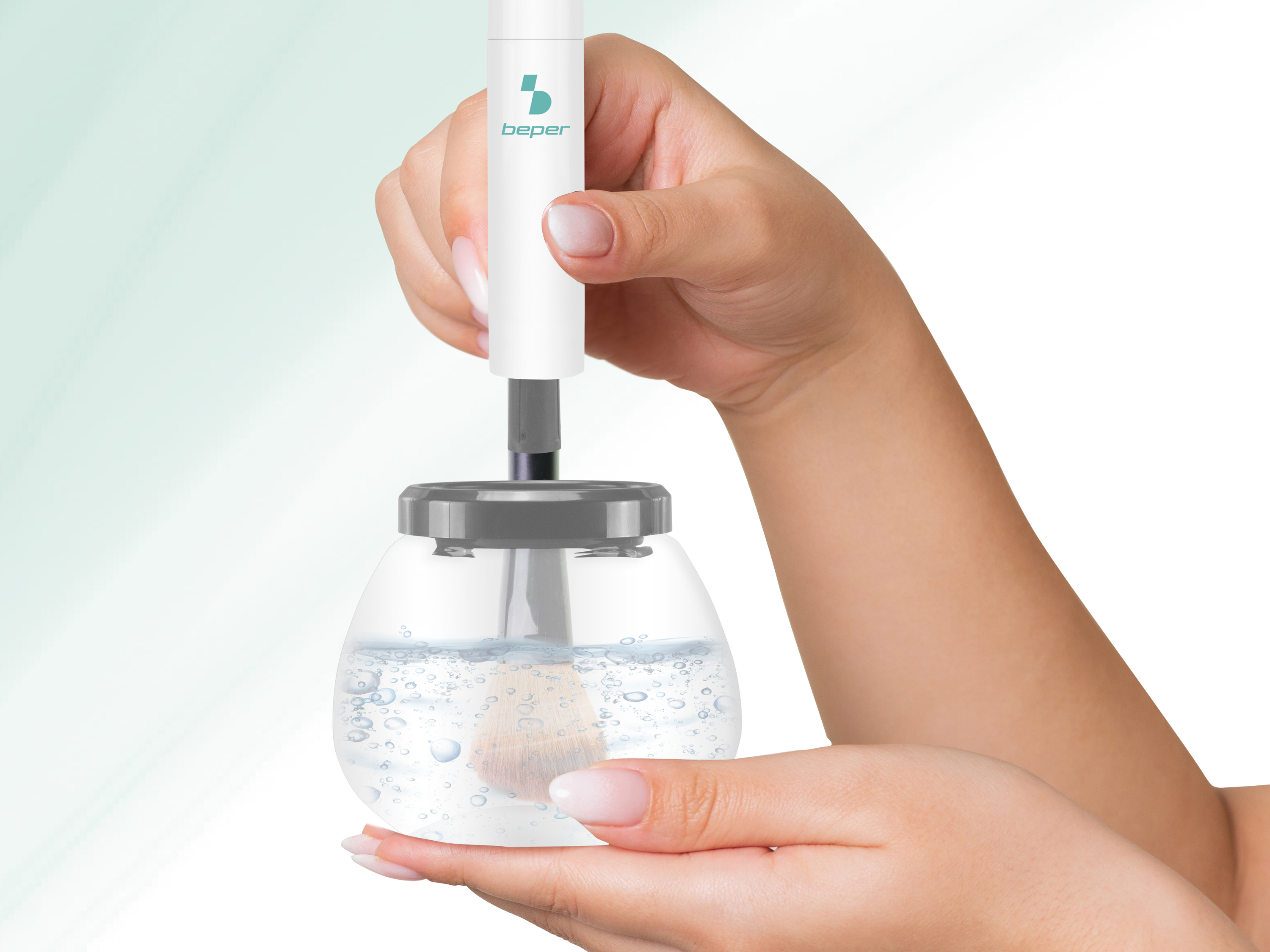 Mani che puliscono un pennello da trucco in un contenitore con acqua.