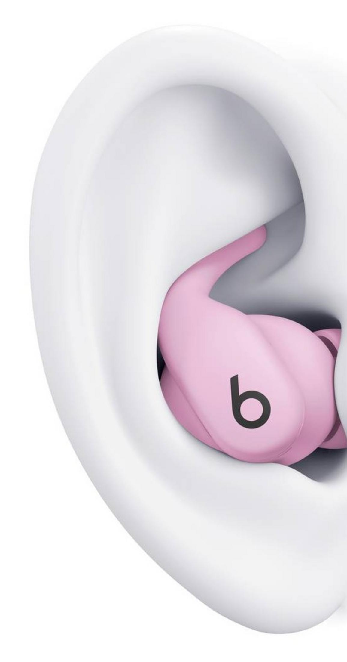 Un auricolare rosa con logo nero 'b' all'interno di un orecchio bianco.