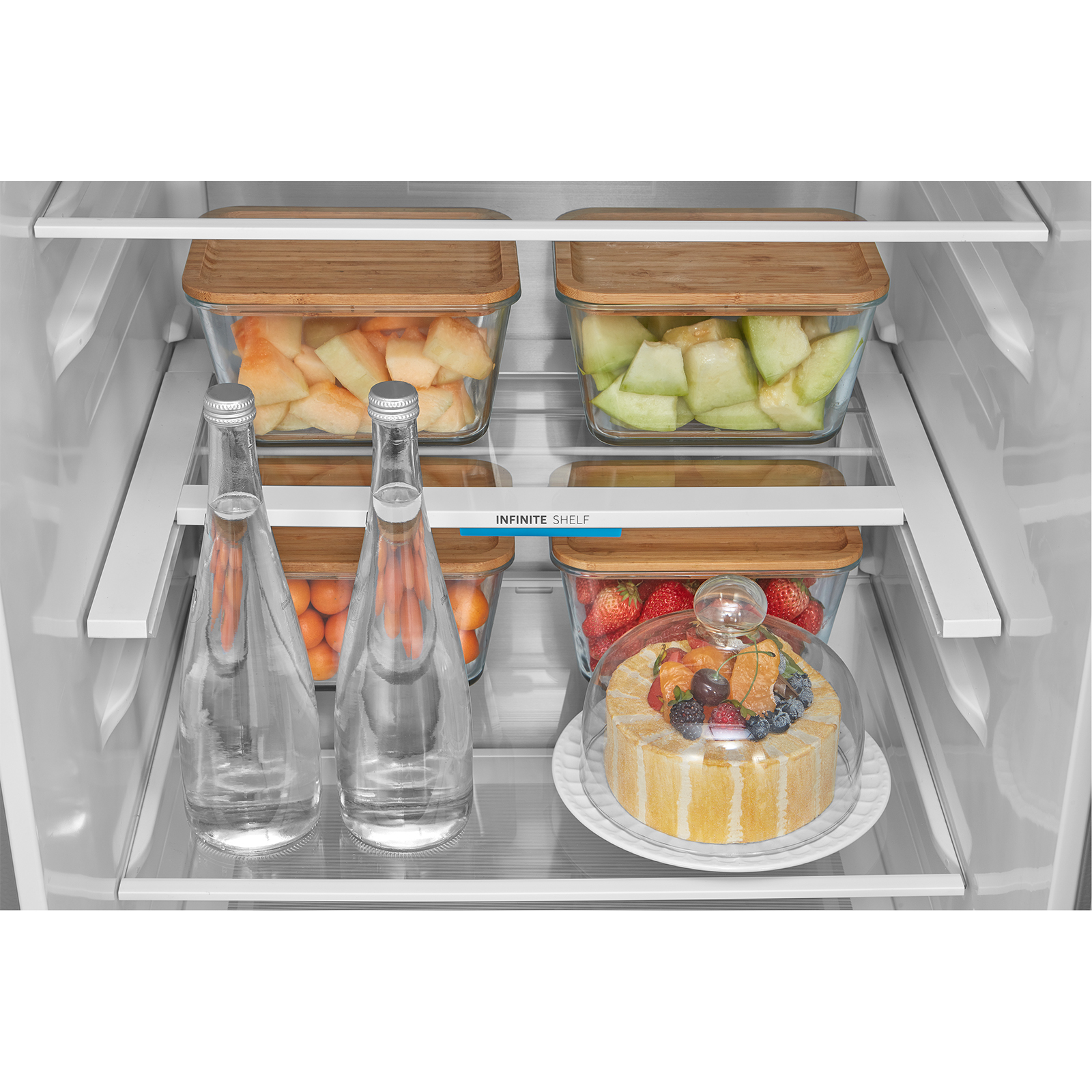 Kühlschrankregale mit Obst, Kuchen und Wasserflaschen.