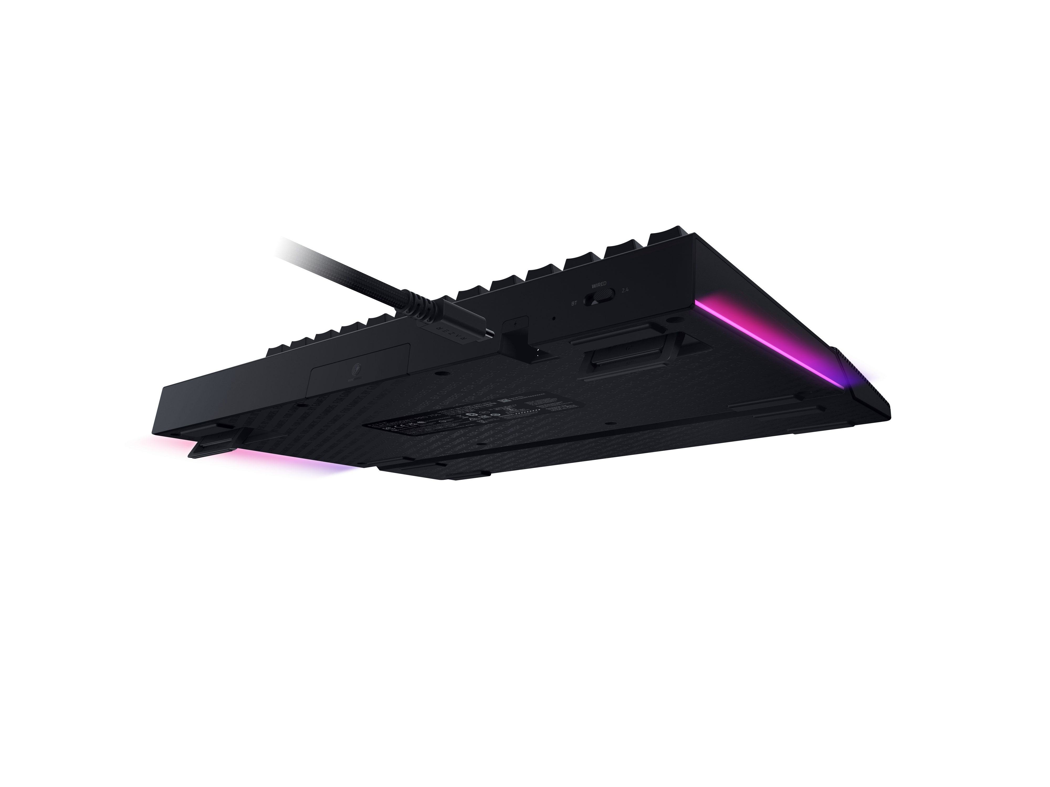 Zwart toetsenbord van onderen gezien met roze verlichting en kabel.