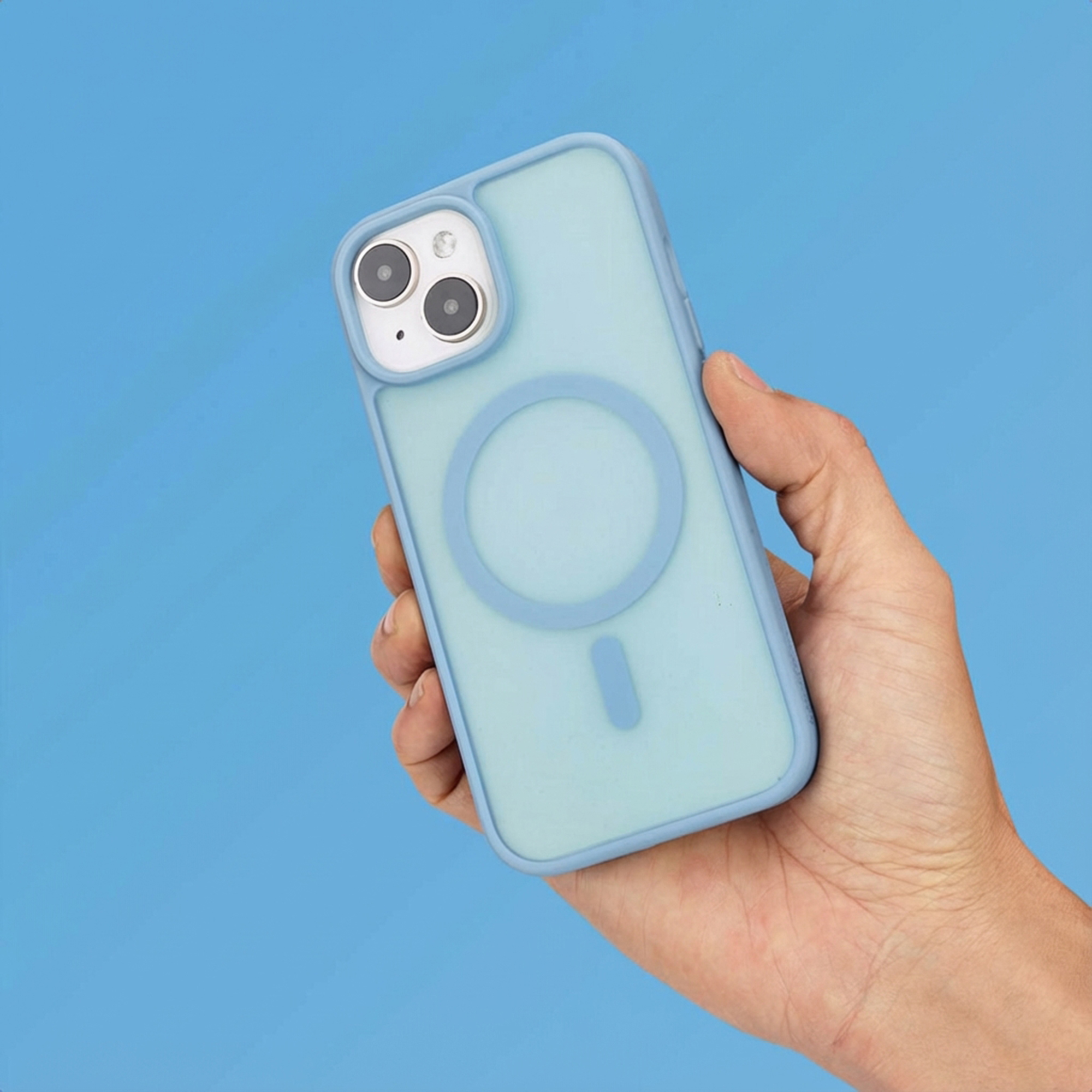 A hand holds a light blue phone case with cameras and a magnetic ring.