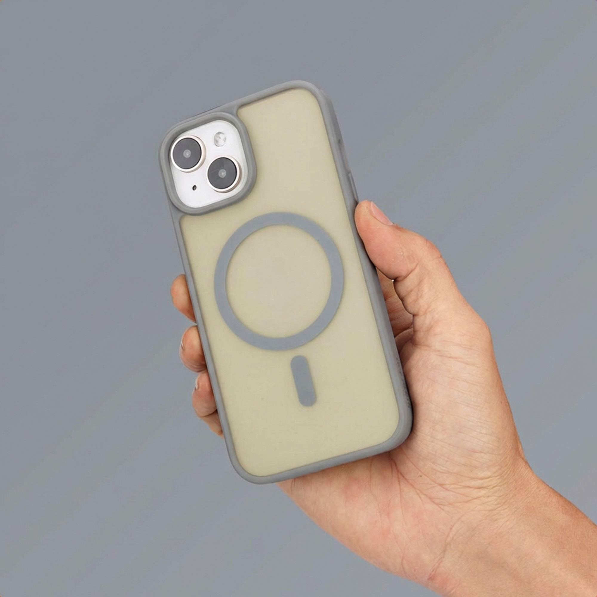Hand holding a light yellow phone case with MagSafe ring and grey edges.