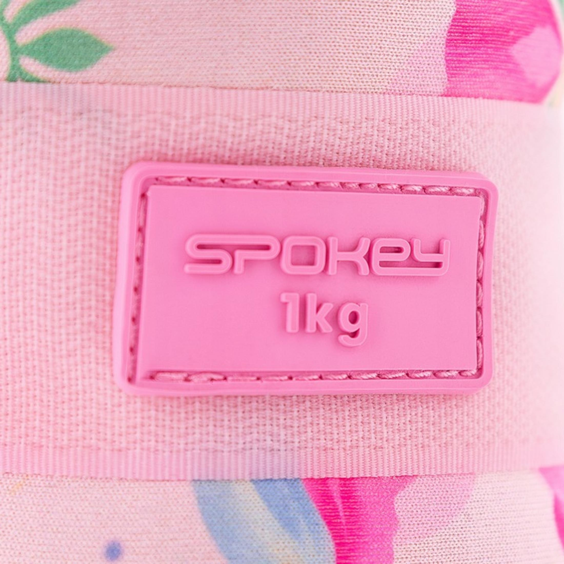Primer plano de una etiqueta rosa con las palabras "SPOKEY 1kg" sobre tela estampada.