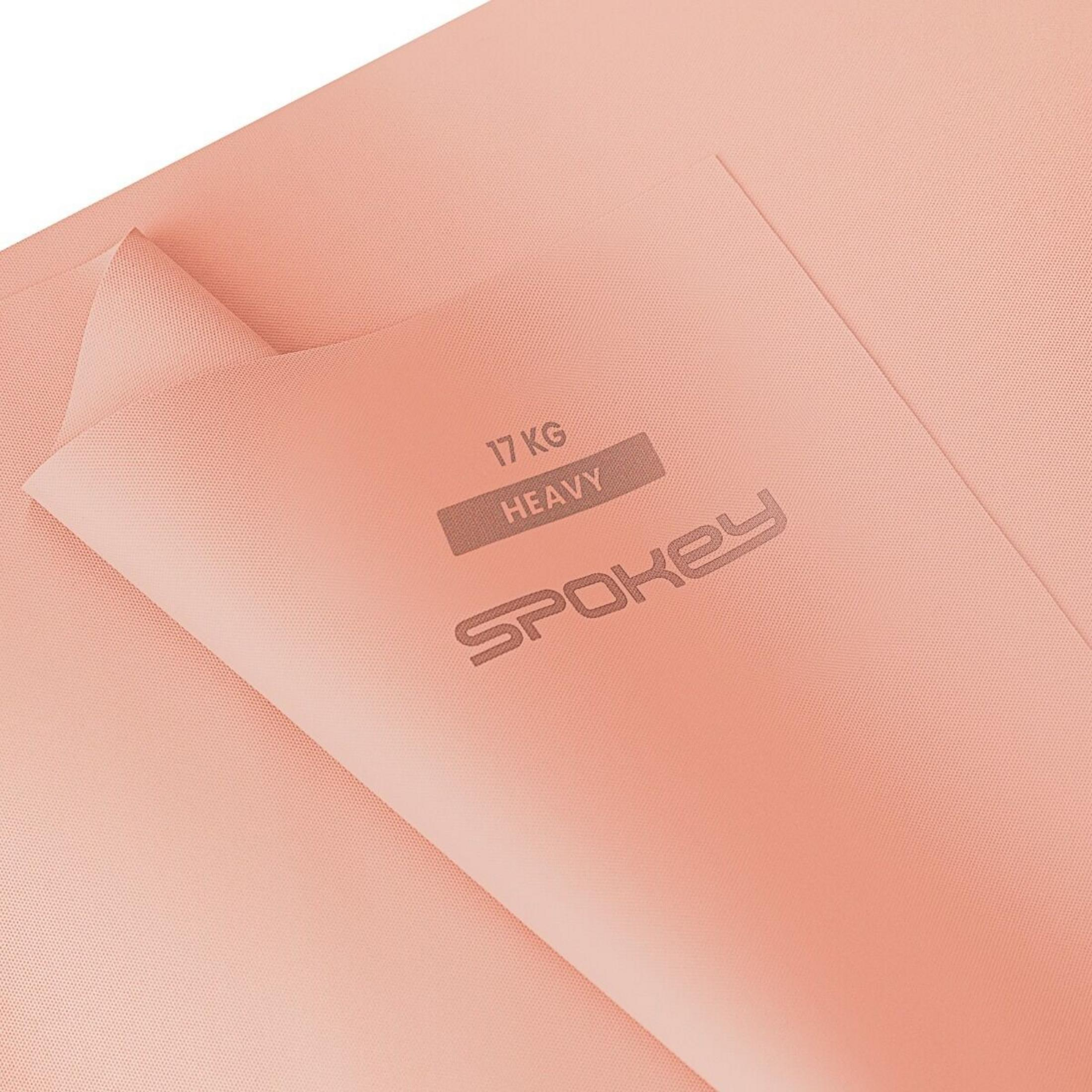 Detalle de alfombrilla de yoga color melocotón con logo 'Spokey' y texto '17 KG HEAVY'.