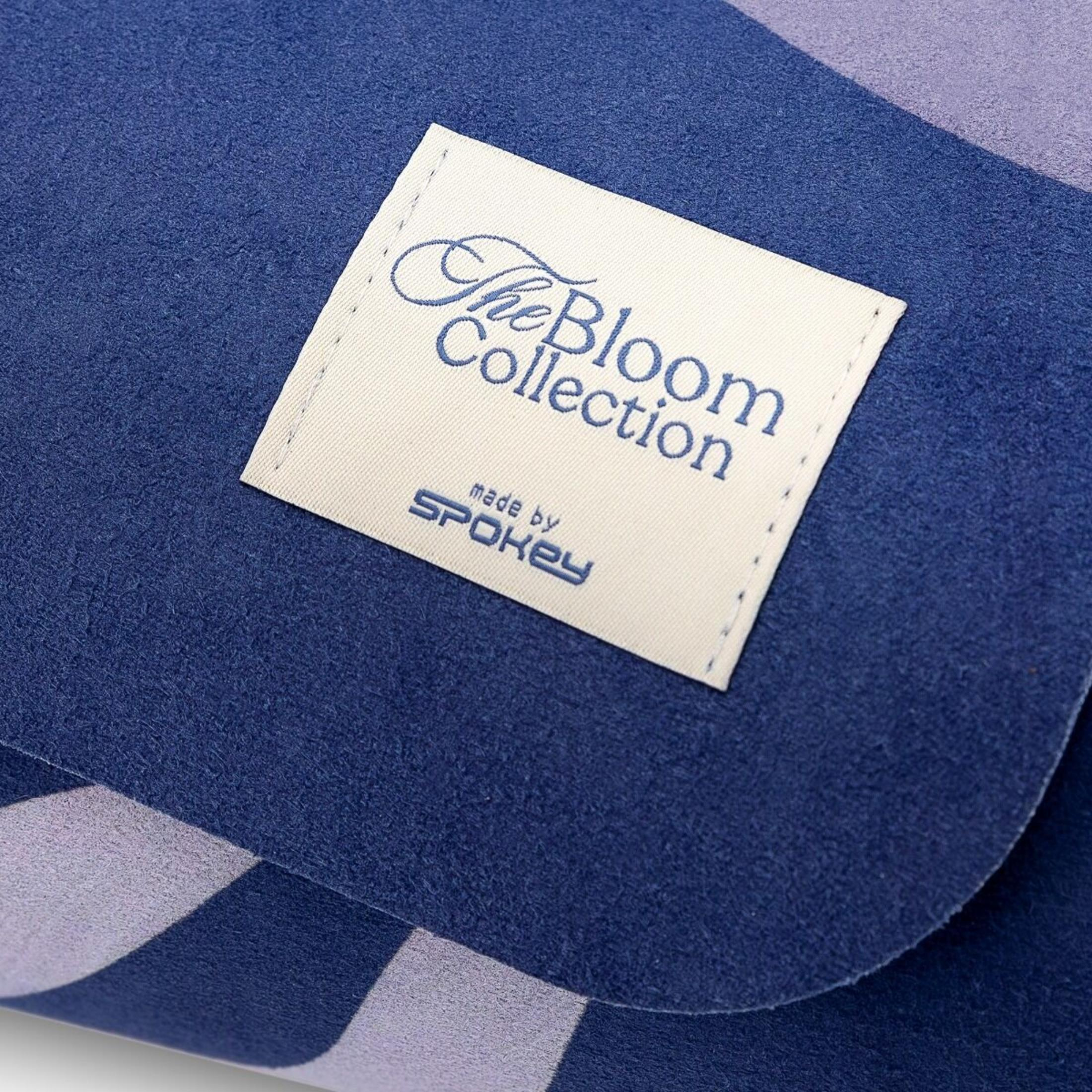Un paño azul con una etiqueta que dice 'The Bloom Collection' y 'made by SPOKEY'.