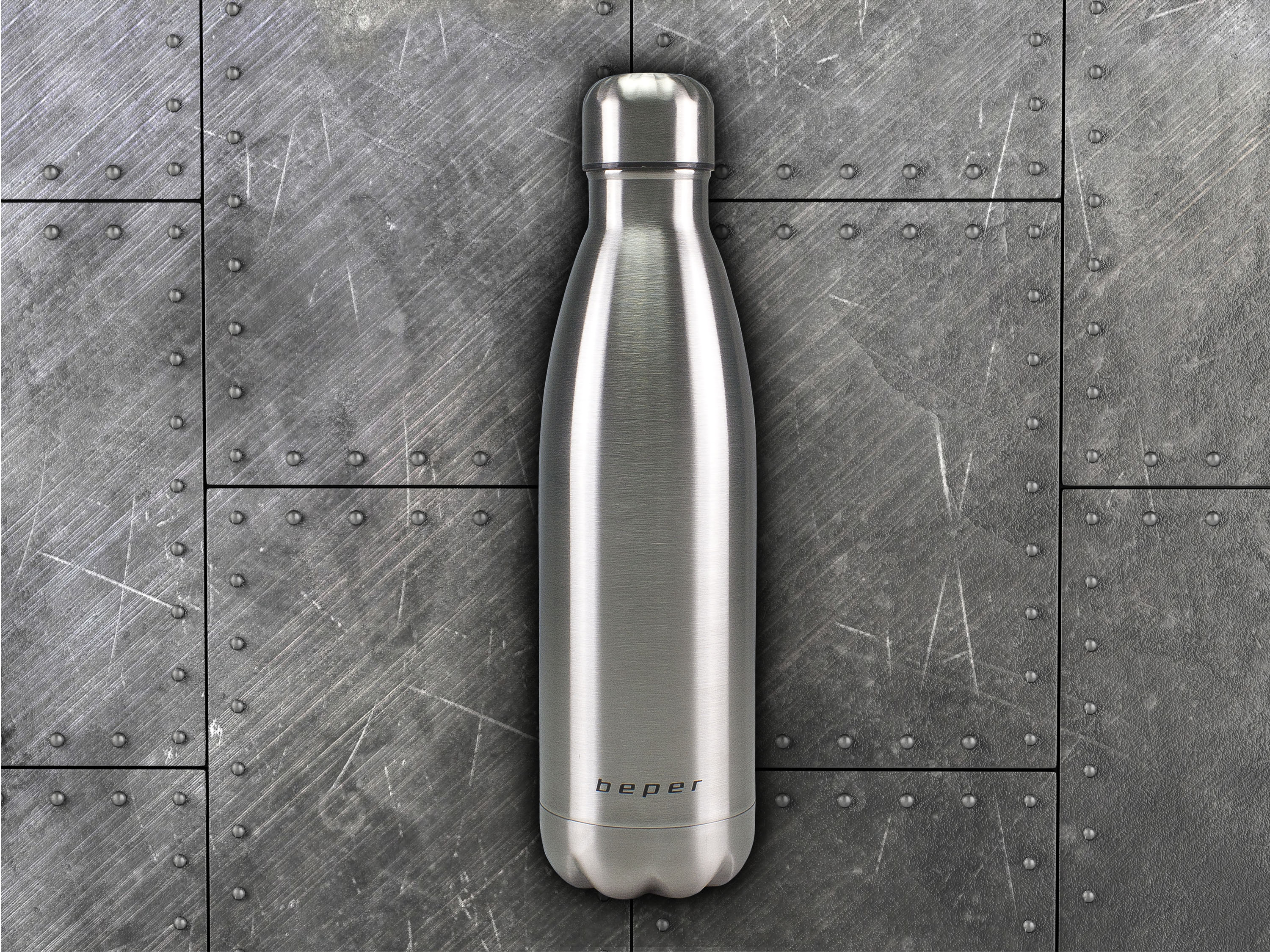 Una borraccia d'argento su sfondo metallico con rivetti.