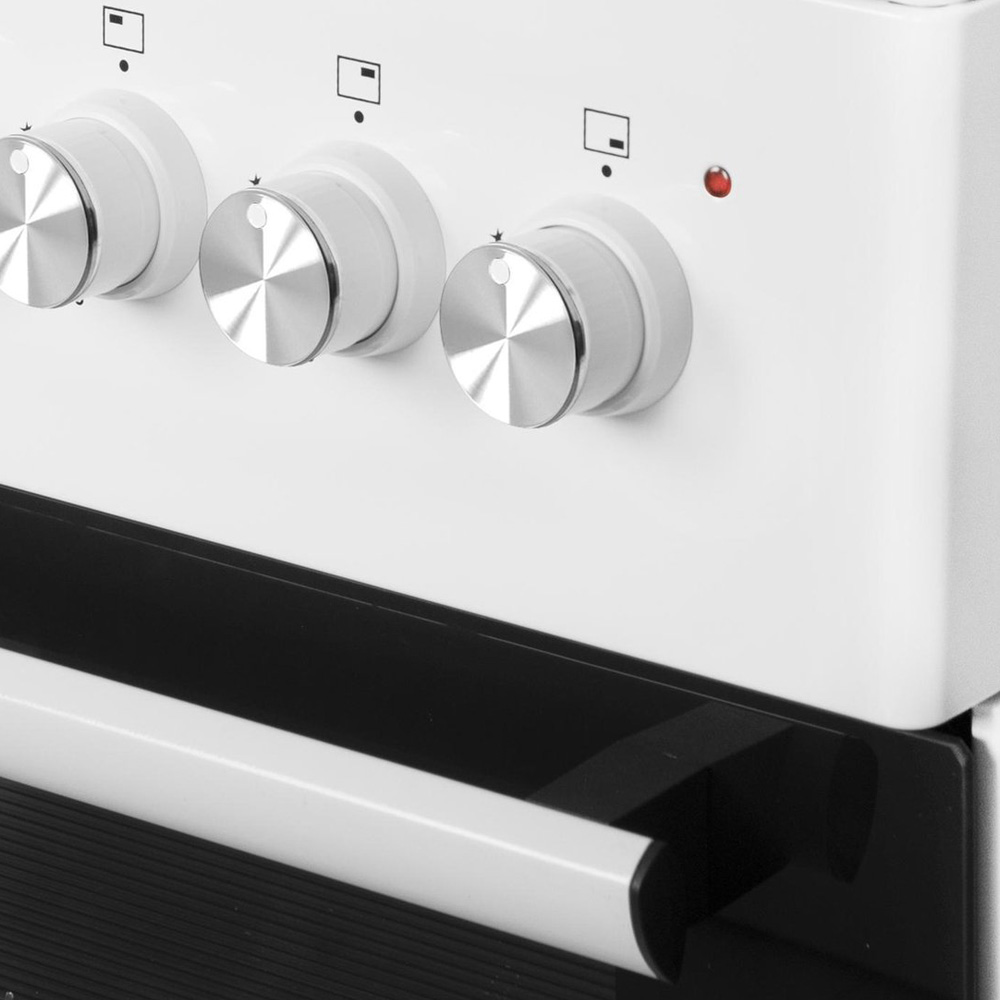 Close-up van drie witte bedieningsknoppen met zilveren accenten op een witte oven.