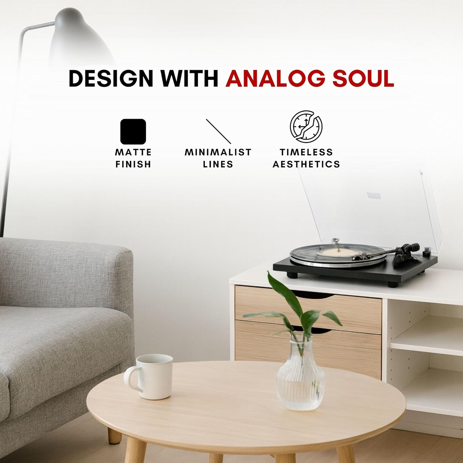 Un tocadiscos está en un mueble blanco junto a un sofá. Una mesa con una taza está delante.