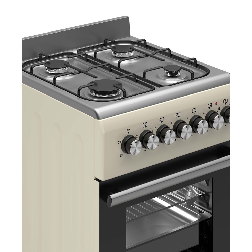 Une cuisinière à gaz crème avec quatre brûleurs et des boutons argentés.