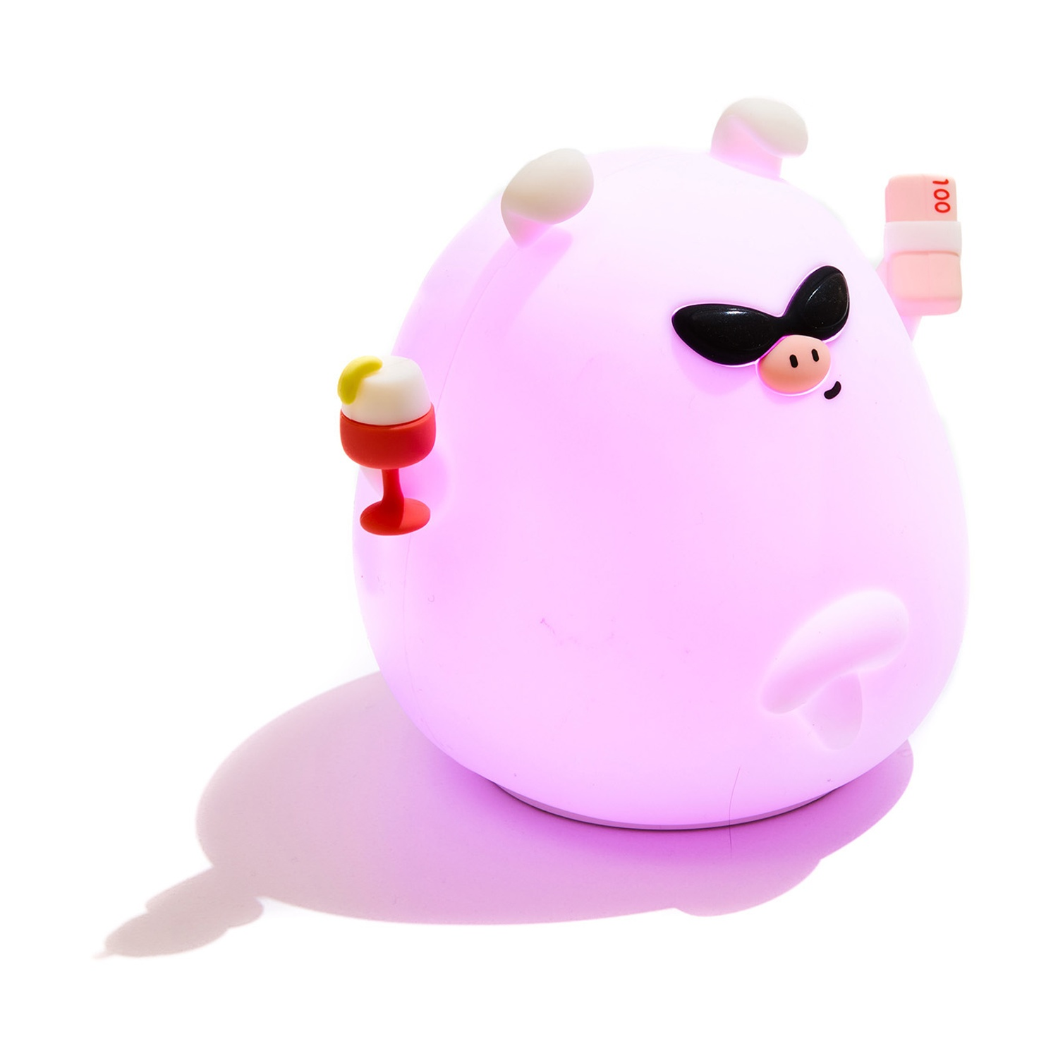 Una figura di maiale rosa luminosa con occhiali da sole, che tiene un drink e soldi.