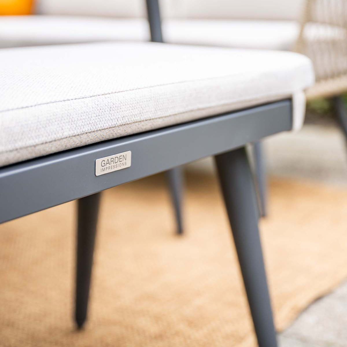 Chaise de jardin grise avec coussin beige et étiquette "GARDEN IMPRESSIONS".