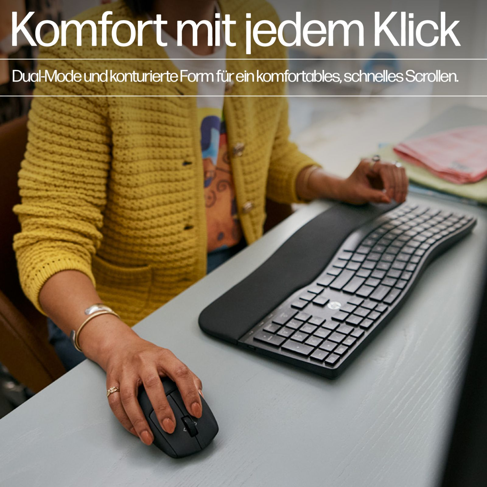 Una persona con cárdigan amarillo usa ratón y teclado.