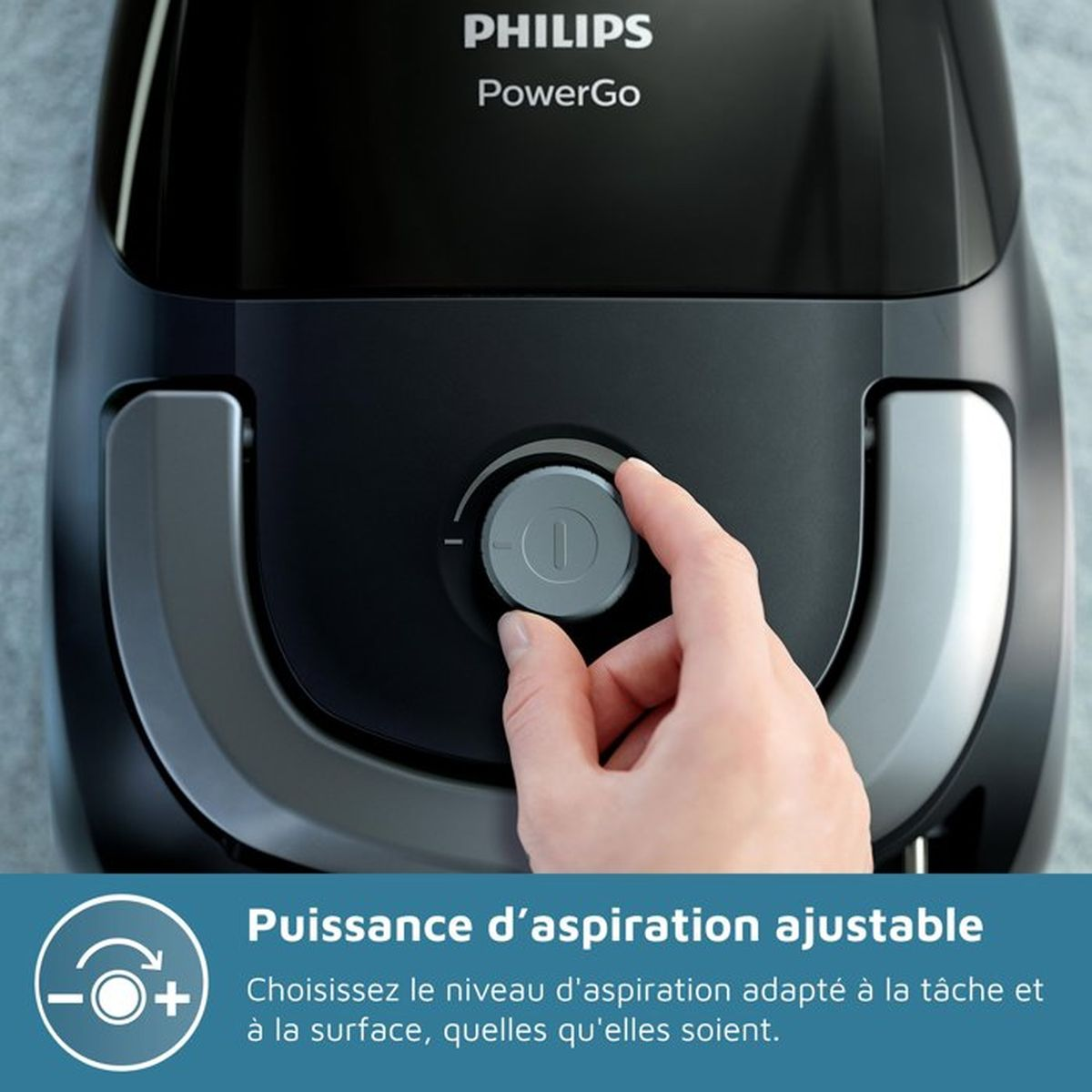 Hand stellt einen Drehregler an einem schwarzen Philips Staubsauger ein.