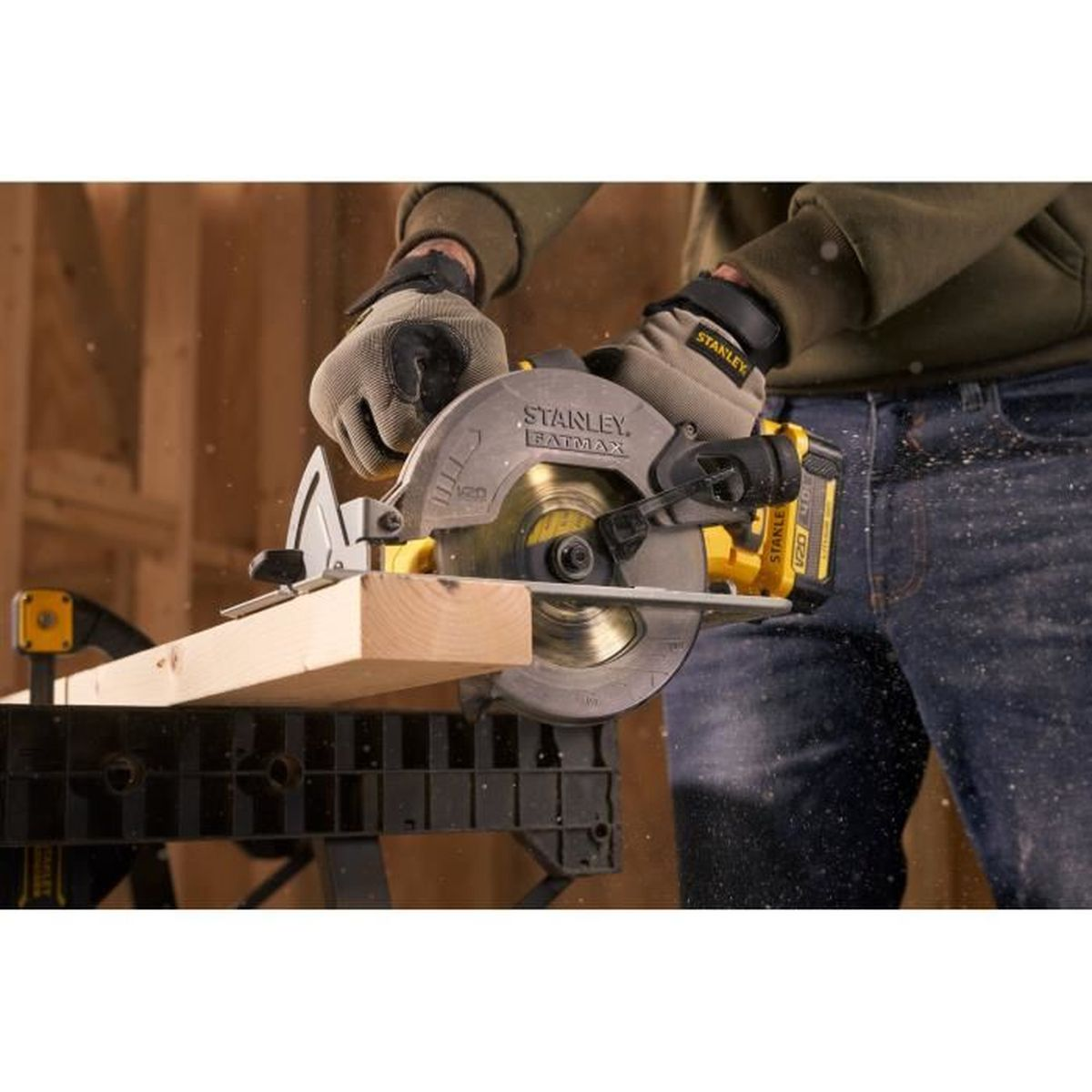 Person mit Handschuhen schneidet Holz mit Kreissäge.