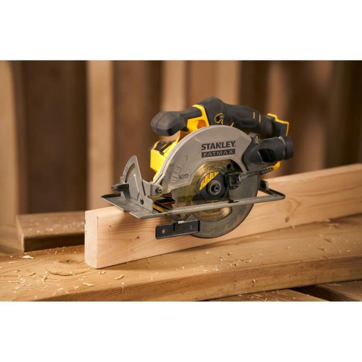 Eine gelbe und graue Kreissäge liegt auf einem Holzbrett. Sägespäne liegen herum.