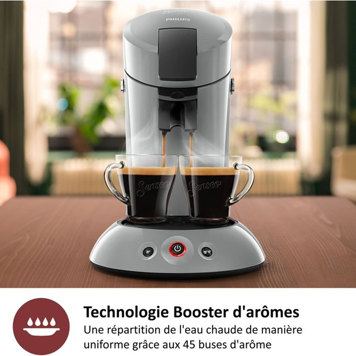 Grijze Philips koffiemachine zet twee koppen koffie, op een houten tafel.