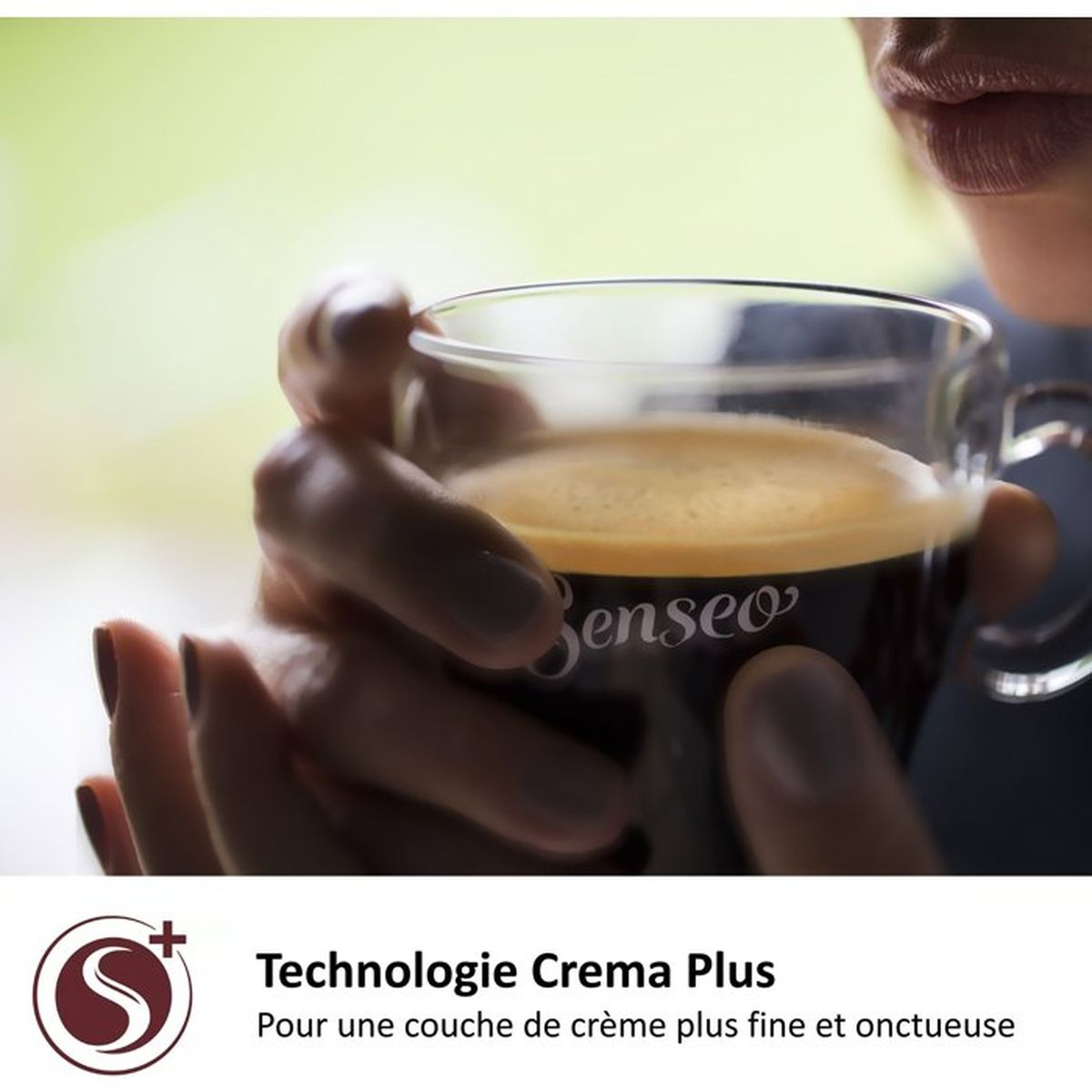 Een persoon houdt een koffiekop vast met bruine koffie en romig schuim.