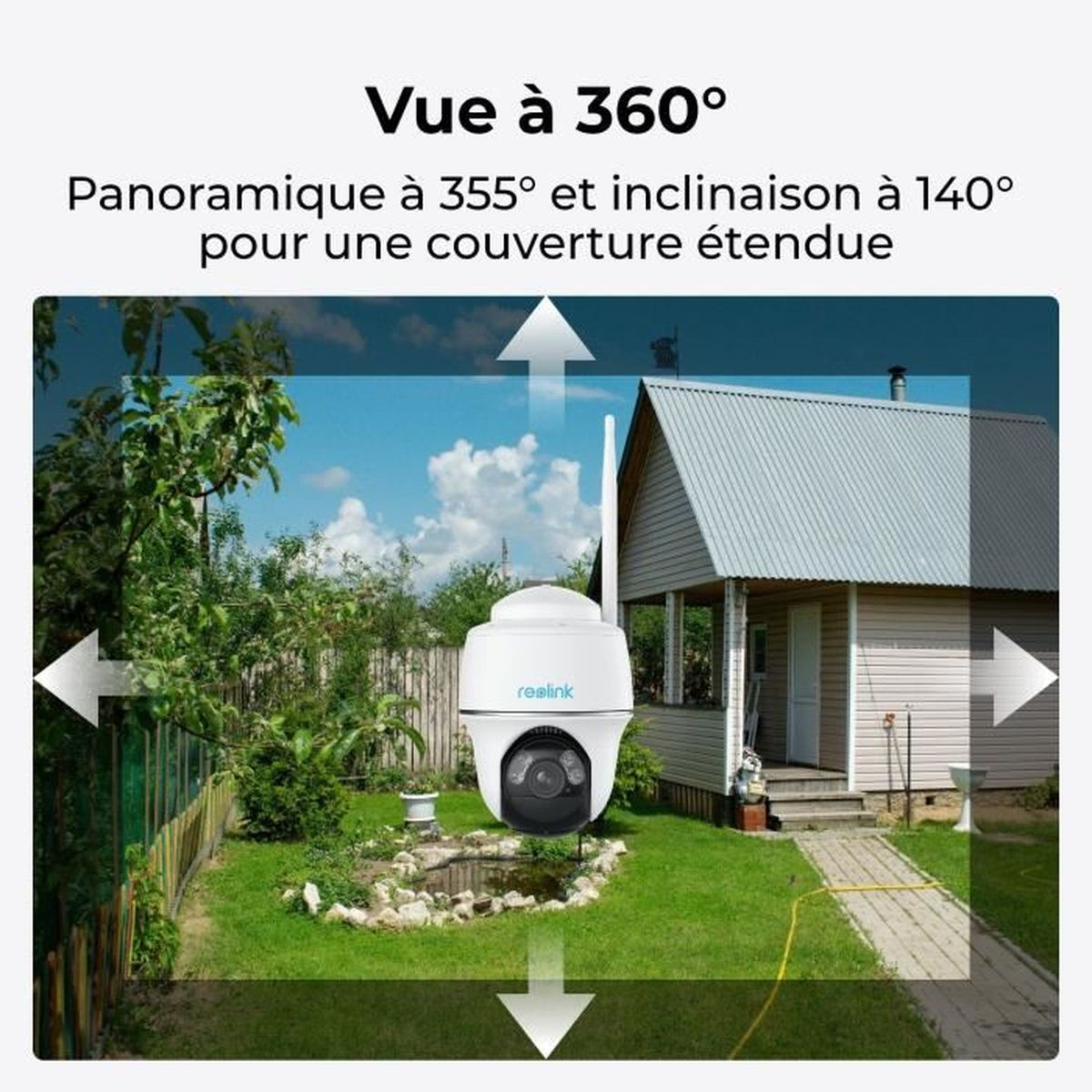 Eine weiße Überwachungskamera mit Antenne steht im Garten vor einem Haus.