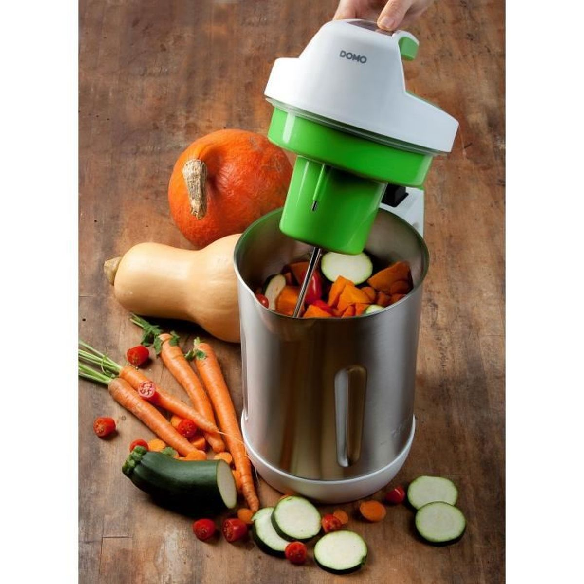 Un elettrodomestico lavora verdure come carote, zucchine e zucca.