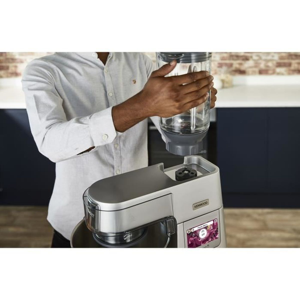 Mann in hellem Hemd befestigt Mixerkrug an Kenwood Küchenmaschine.