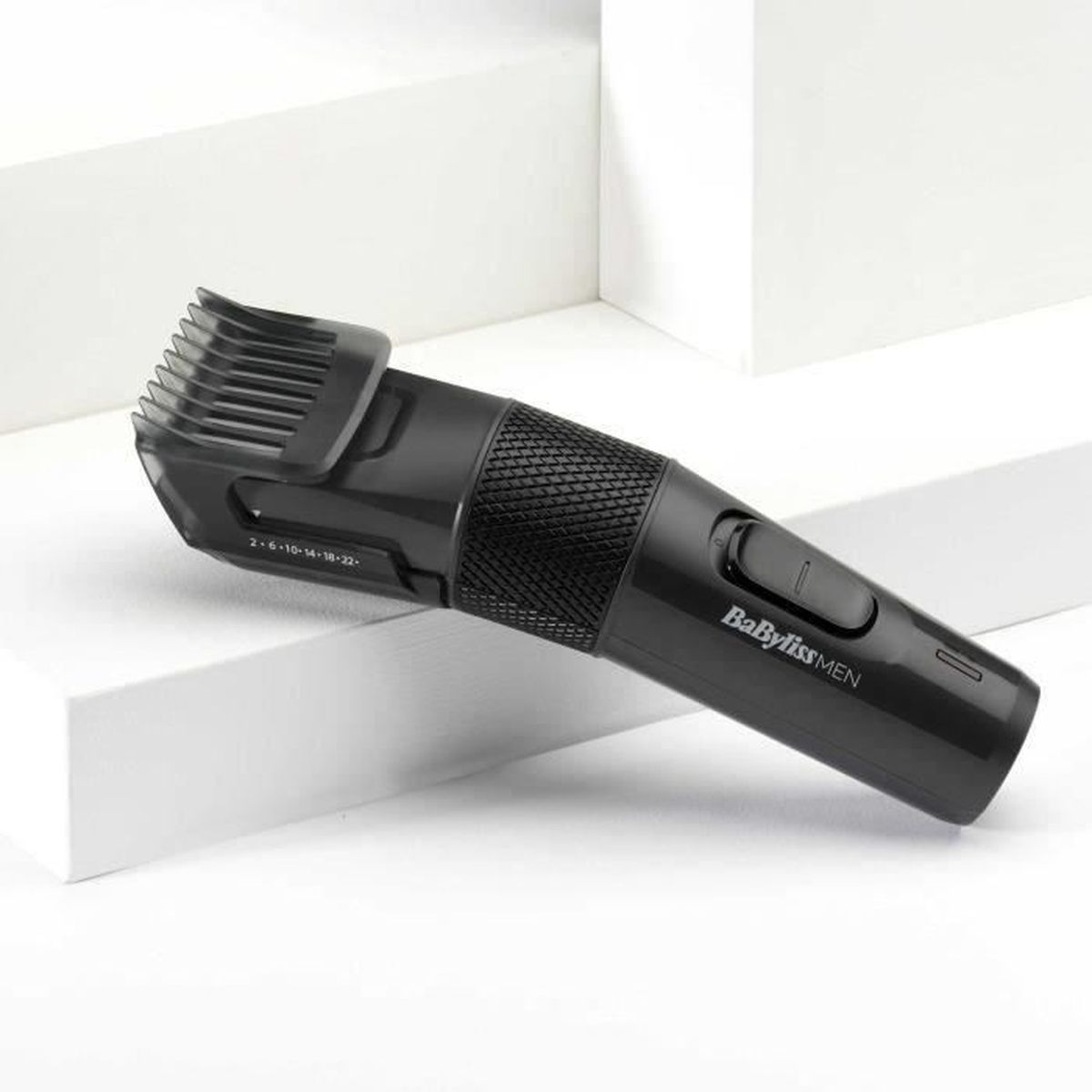 Schwarzer BaByliss MEN Trimmer mit verstellbarem Kammaufsatz auf weißen Oberflächen.